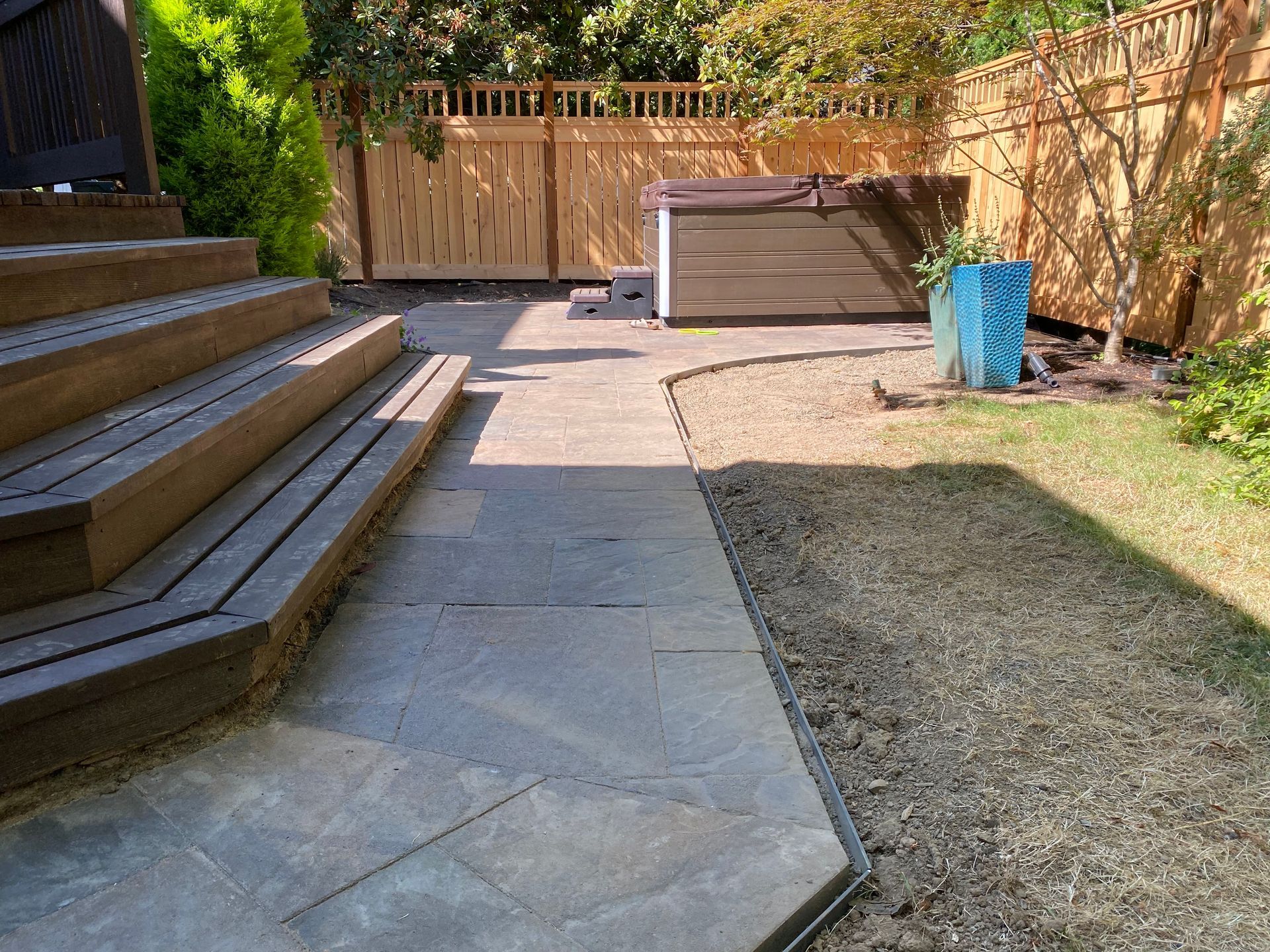 A patio with stairs and a hot tub in the backyard