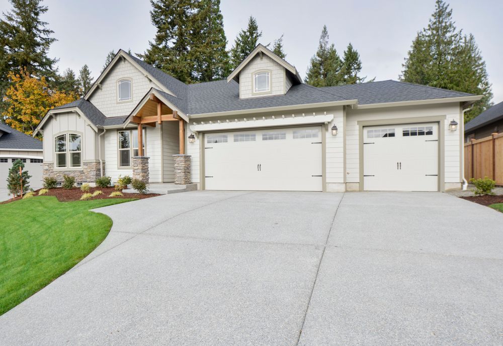 A house with two garage doors and a concrete driveway