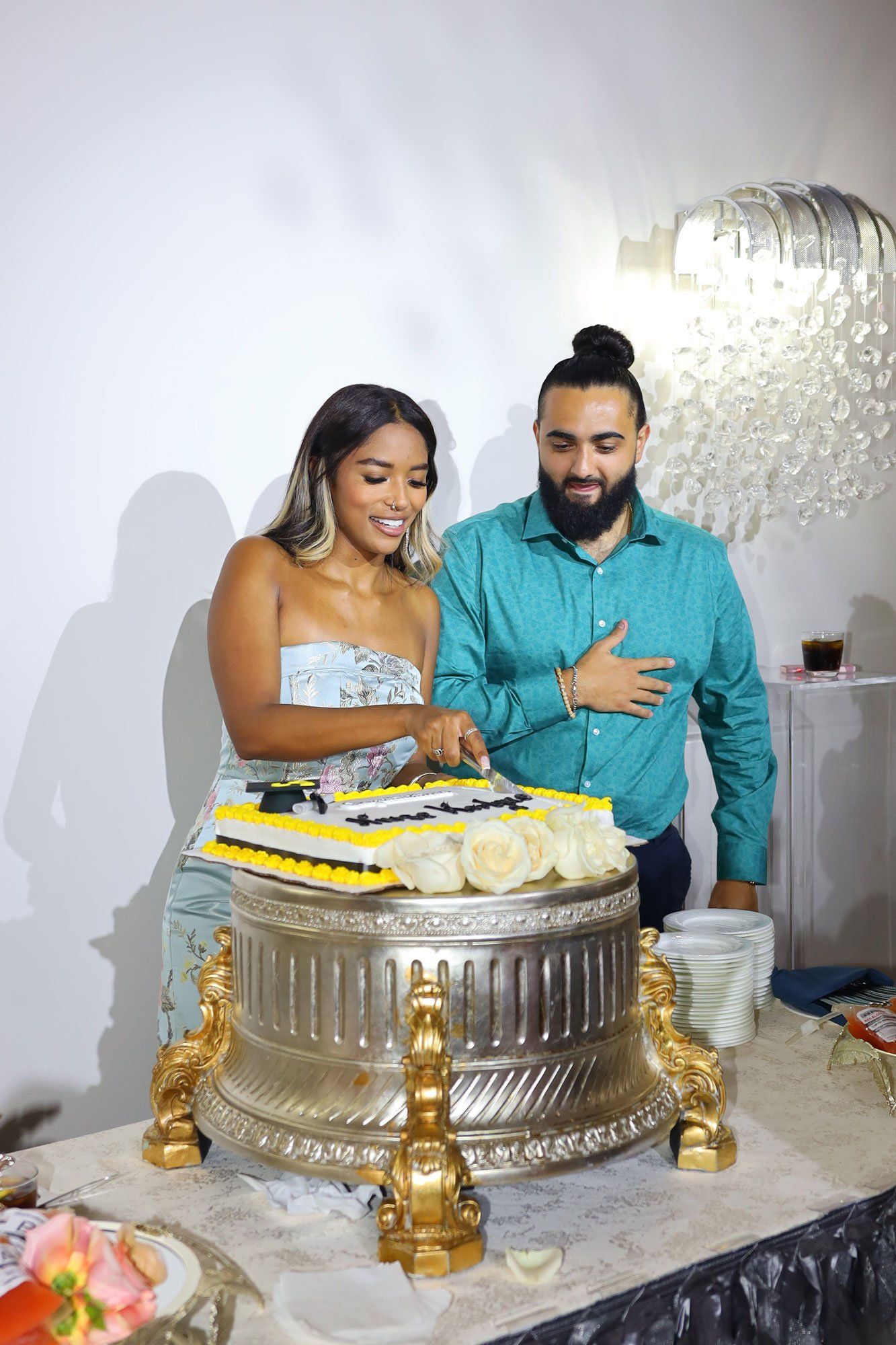 woman and man cutting a graduation cake
