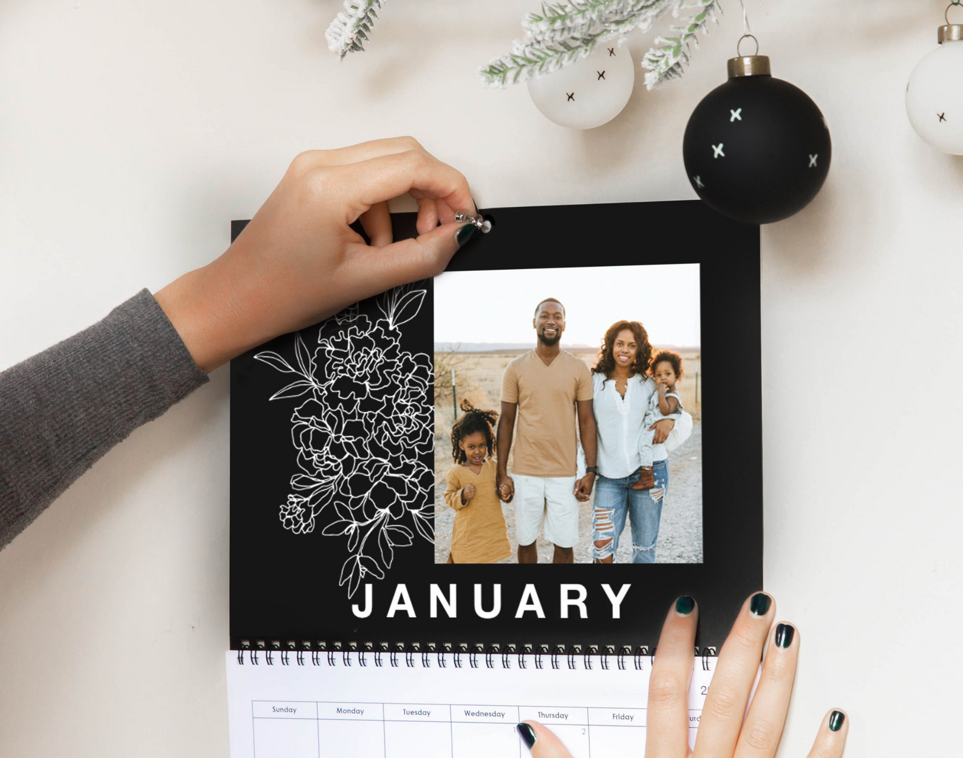 A person is holding a calendar with a picture of a family on it.