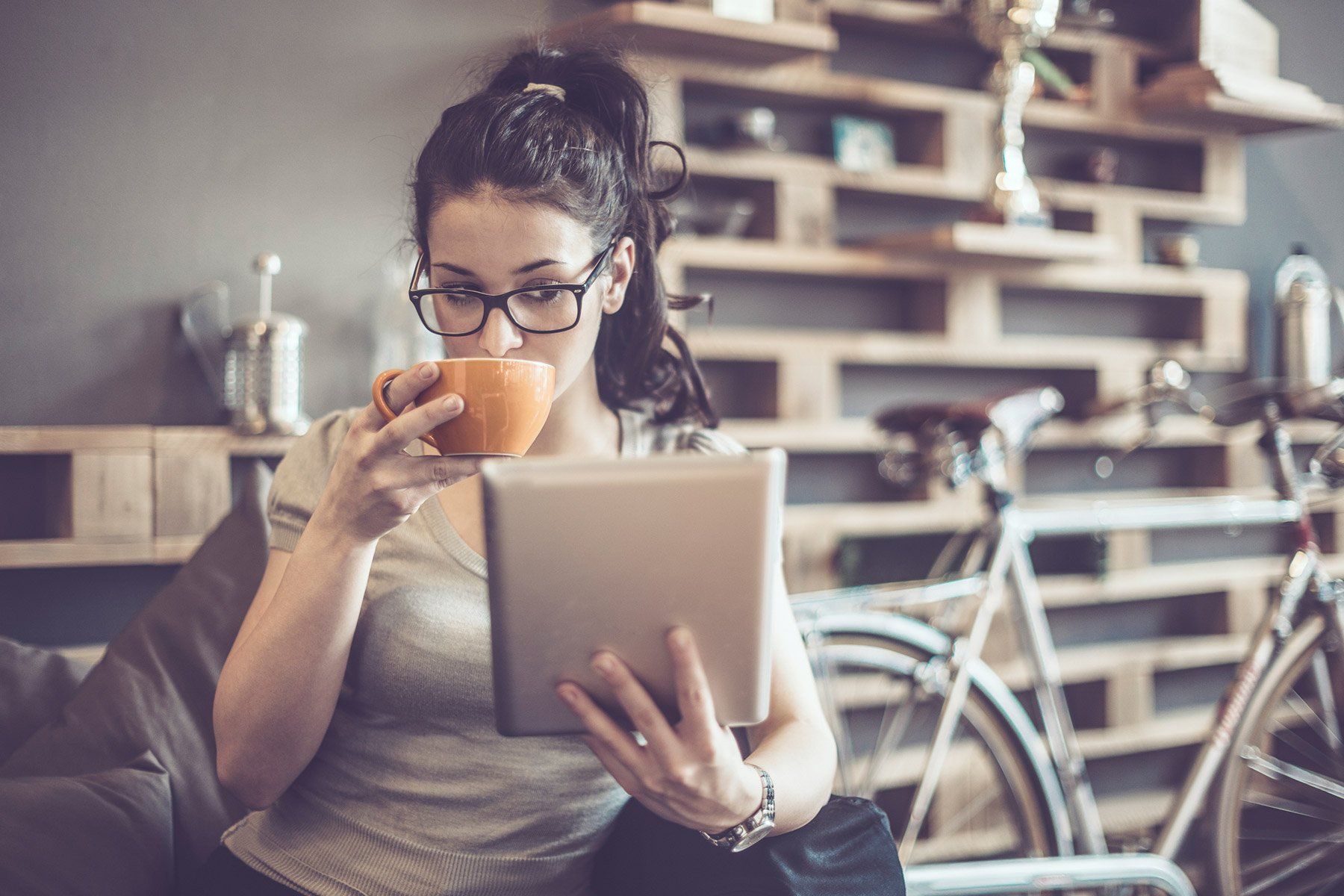 Tenant using iPad while drinking coffee.