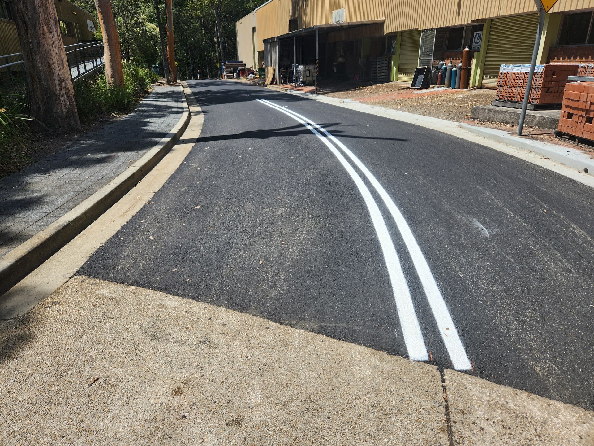 Newly Paved Asphalt Road With White Dividing Lines — TAC Asphalt Services in Warners Bay, NSW