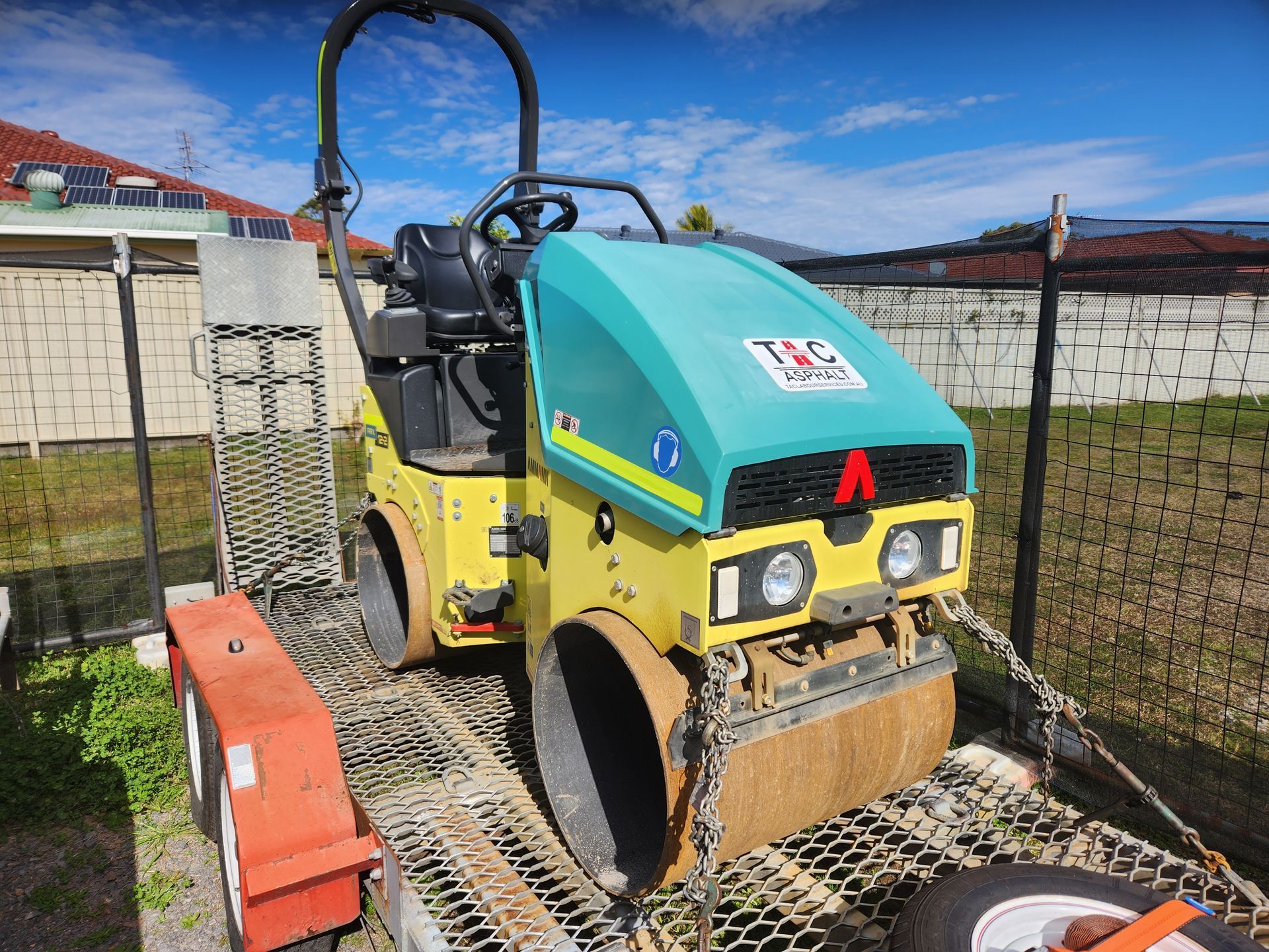 Yellow And Teal Road Roller On A Trailer — TAC Asphalt Services in Warners Bay, NSW