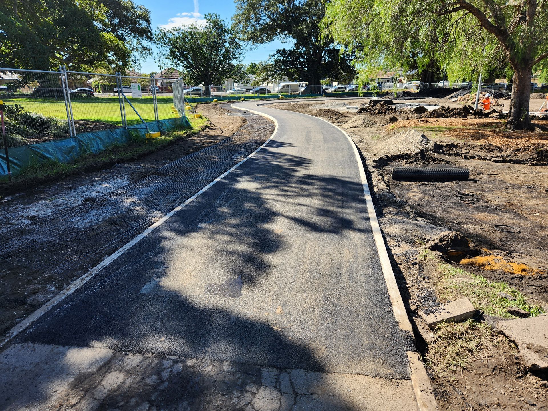 New Paved Pathway Curves Through a Park With Dirt Construction Areas — TAC Asphalt Services in Port Stephens, NSW