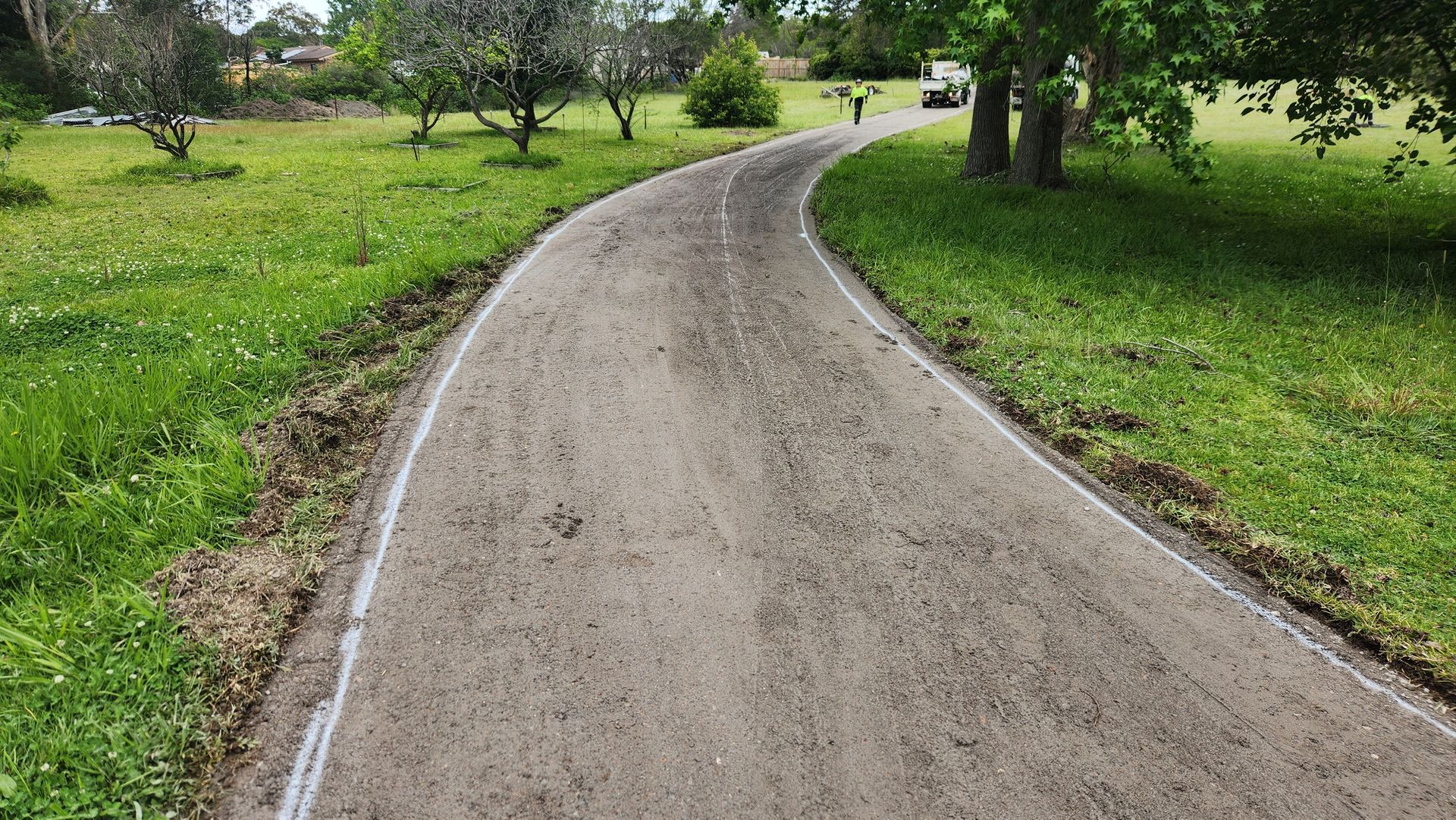 Gravel Driveway Curves Through Grassy Area, Bordered By Dirt — TAC Asphalt Services in Warners Bay, NSW