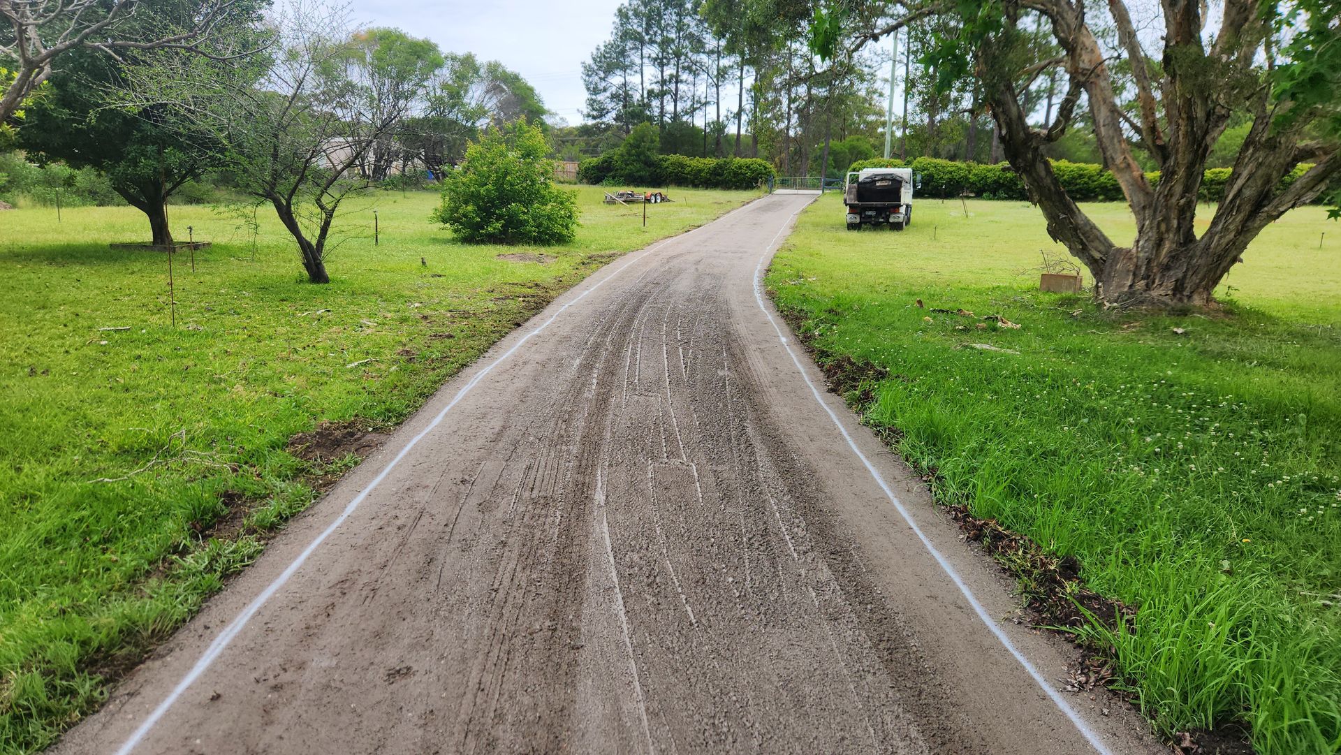 Dirt Road Through A Grassy Field — TAC Asphalt Services in Warners Bay, NSW