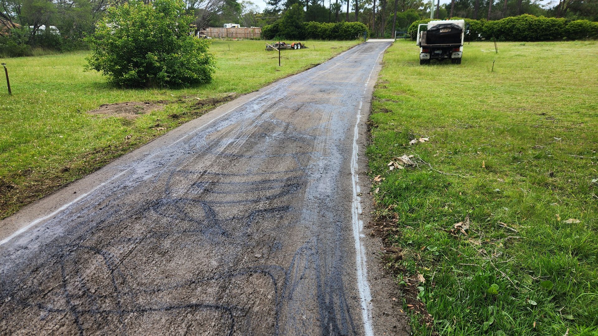 Gravel Driveway Leading To A Vehicle Parked On Green Grass — TAC Asphalt Services in Warners Bay, NSW