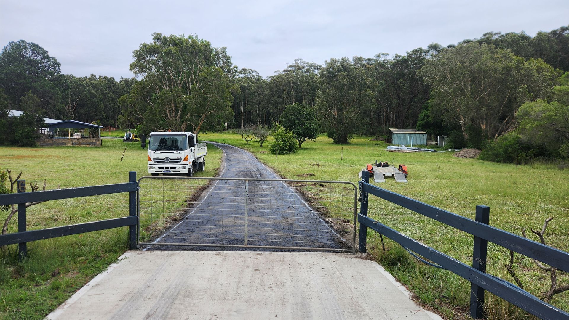 Gray Gate Opens Onto A Concrete Drive With A Truck — TAC Asphalt Services in Warners Bay, NSW