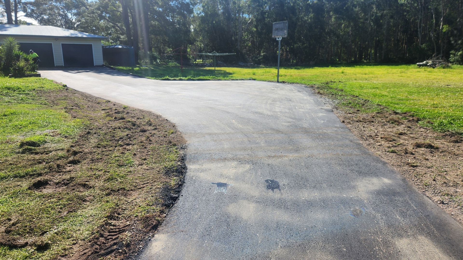 Asphalt Driveway Curves Toward A Two-car Garage — TAC Asphalt Services in Warners Bay, NSW