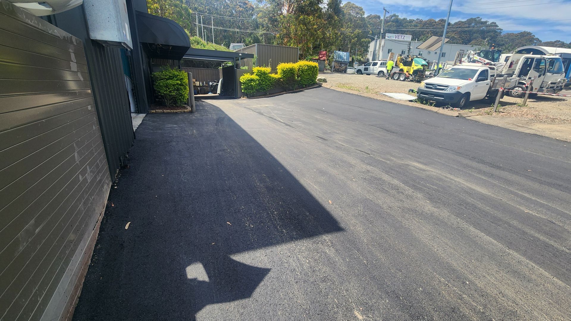 Asphalt Driveway Next to a Building, Leading to Parked Vehicles — TAC Asphalt Services in Lake Macquarie, NSW