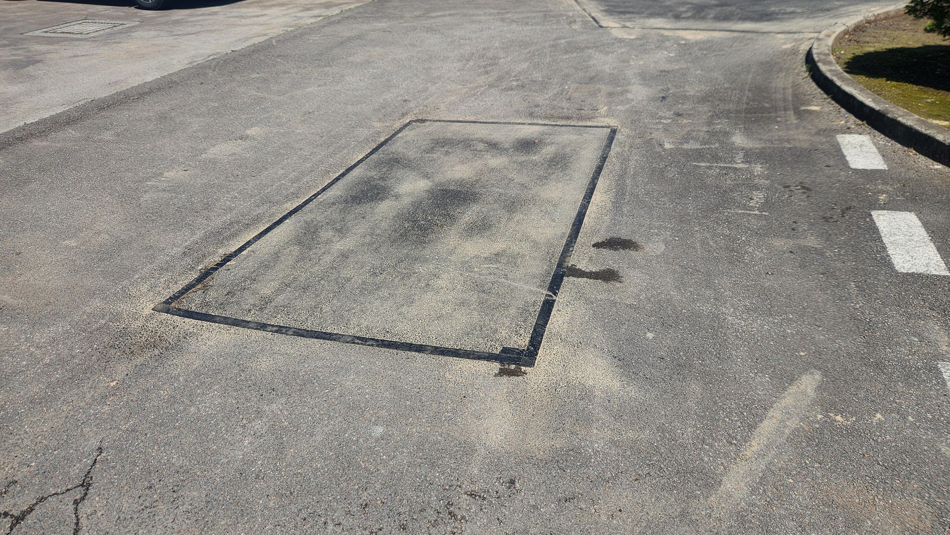 Asphalt Road With A Rectangular Patch Of Darker Asphalt — TAC Asphalt Services in Warners Bay, NSW