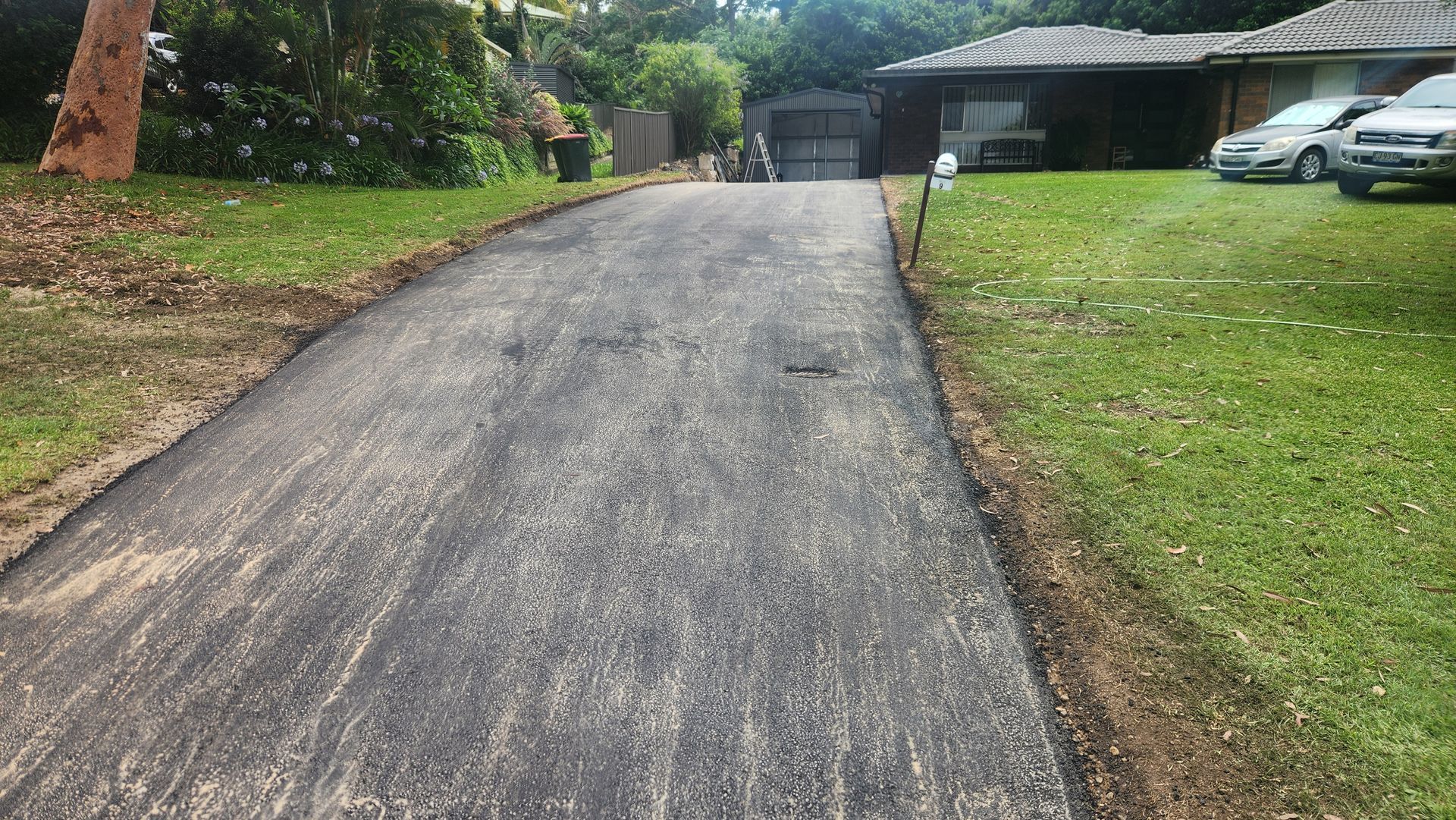 Newly Paved Driveway With Green Grass On Either Side — TAC Asphalt Services in Warners Bay, NSW