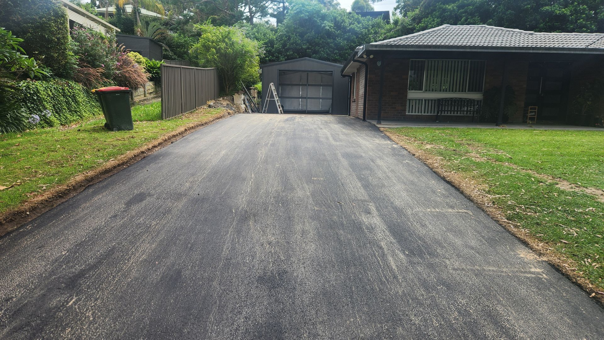 Asphalt Driveway Leading To A Garage — TAC Asphalt Services in Warners Bay, NSW