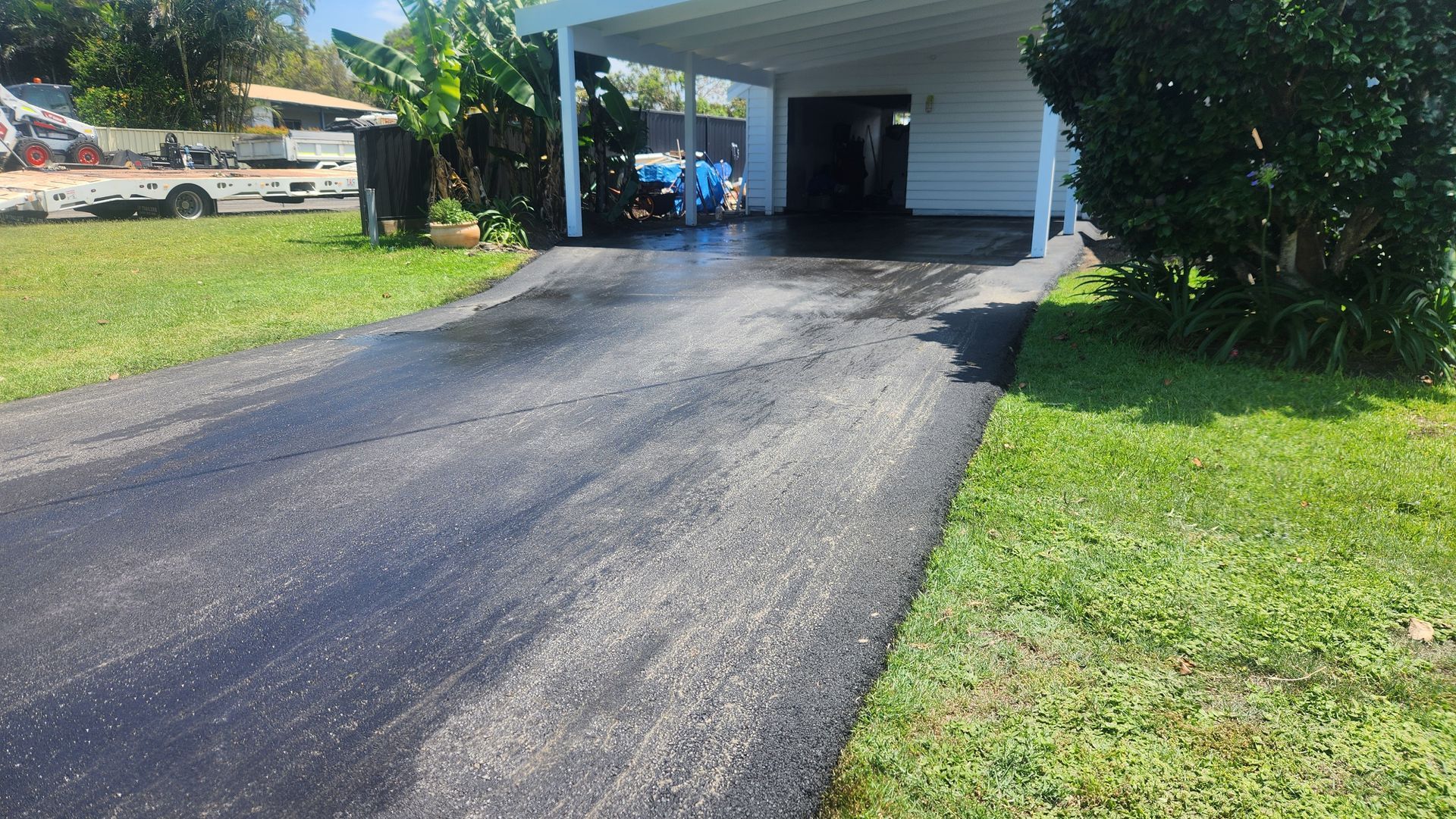 Asphalt Driveway Leading To A Carport, Flanked By Green Grass — TAC Asphalt Services in Warners Bay, NSW