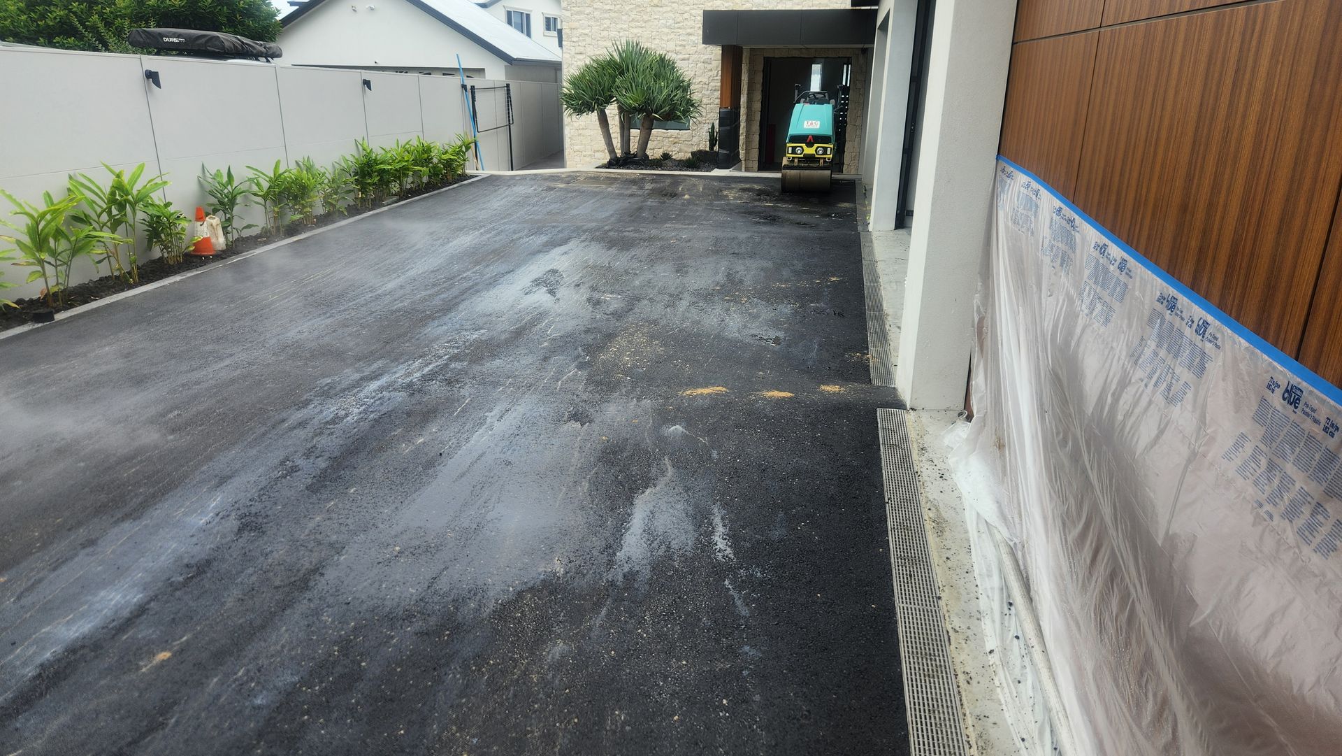 Asphalt Driveway With White Building, Trees, and Small Construction Equipment — TAC Asphalt Services in Raymond Terrace, NSW