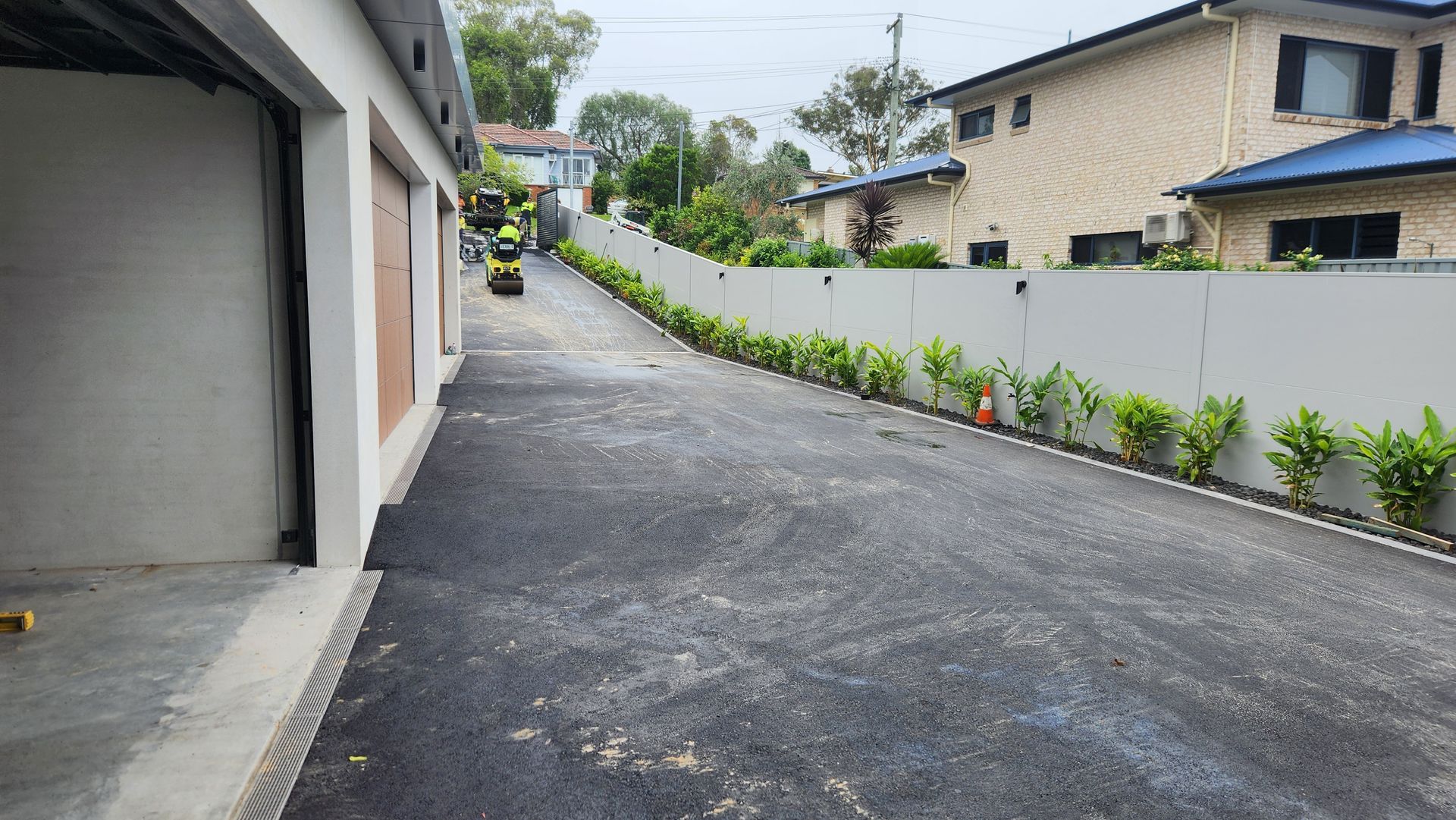 Asphalt Driveway With A Retaining Wall — TAC Asphalt Services in Warners Bay, NSW