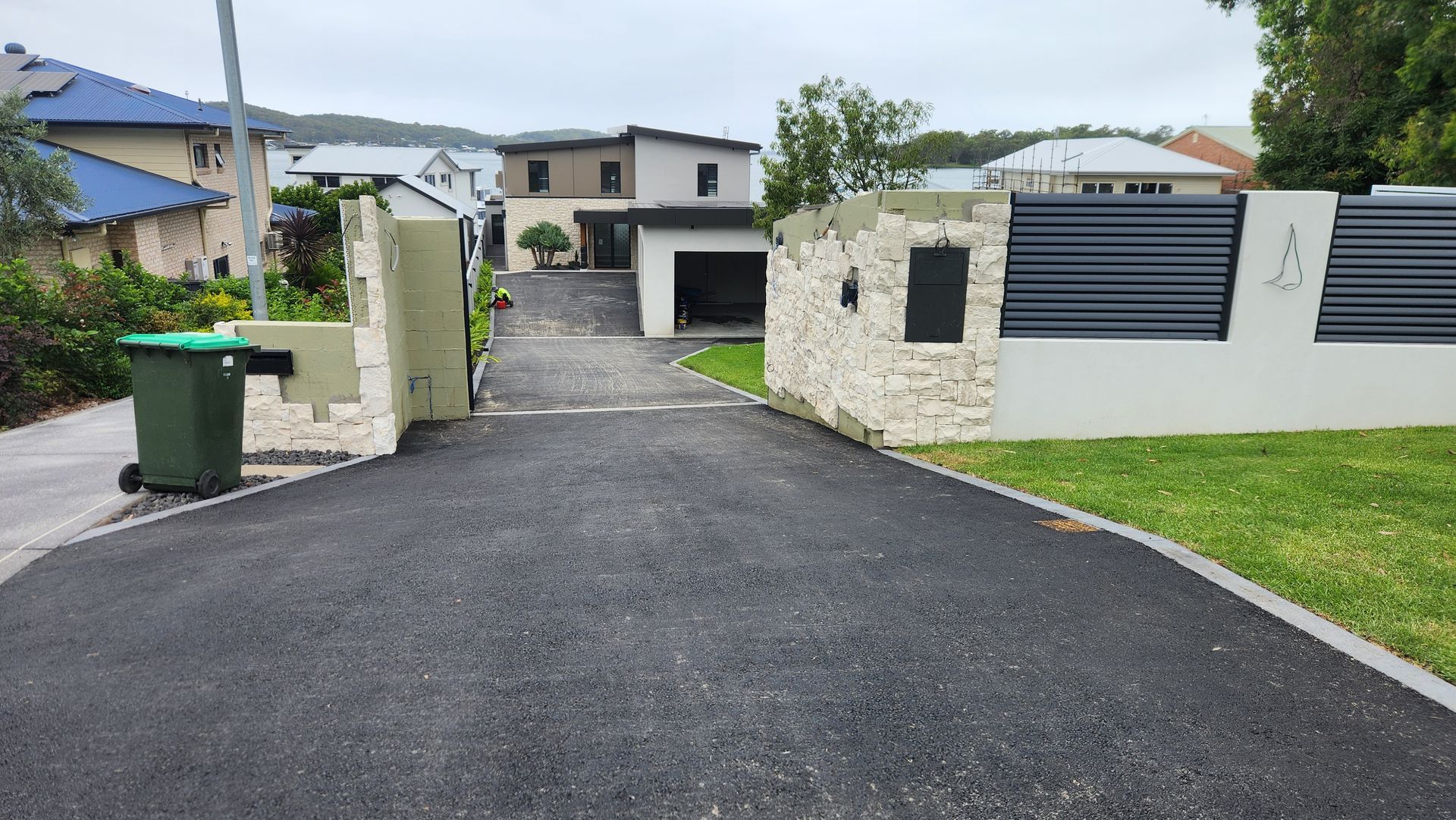 Driveway Leading to House With Stone and Black Metal Gate — TAC Asphalt Services in Warners Bay, NSW