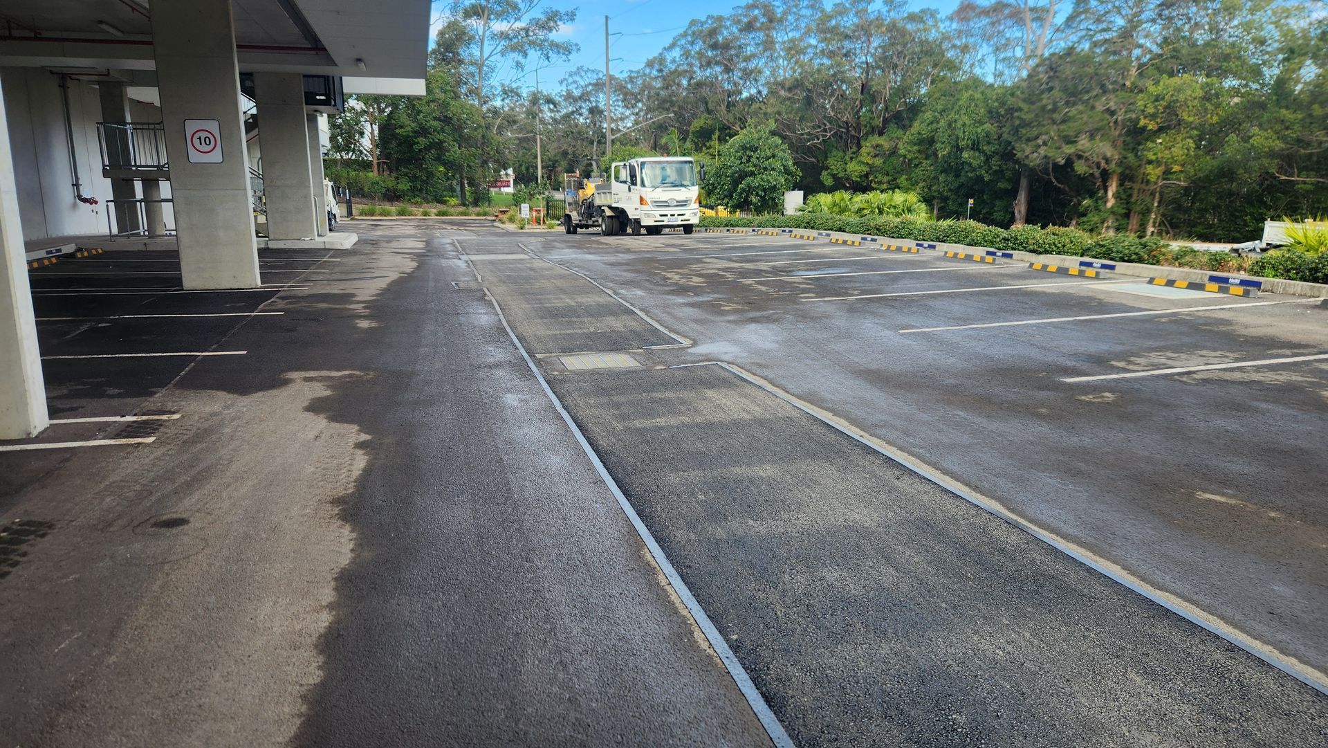 Asphalt Parking Area With a Vehicle in the Distance — TAC Asphalt Services in Lake Macquarie, NSW