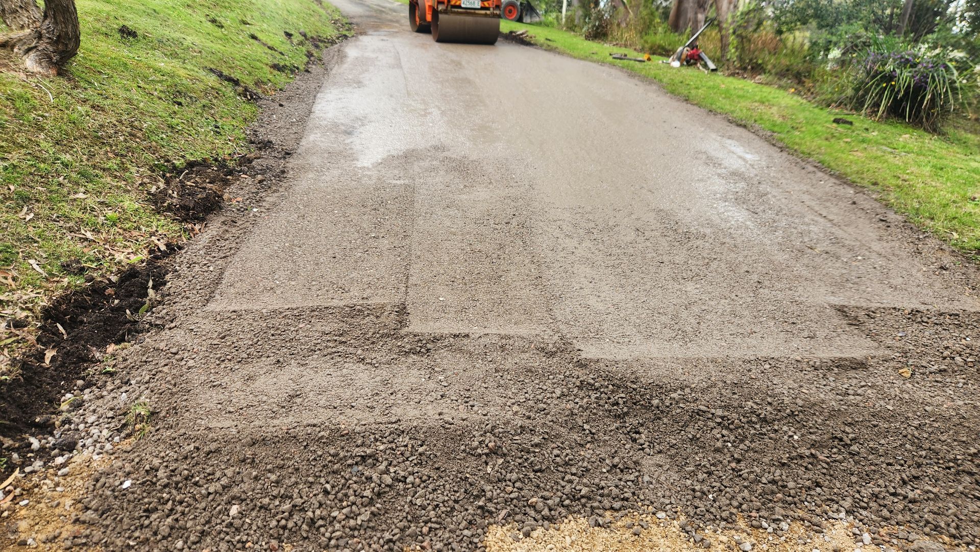 Road Resurfacing In Progress; A Roller Compacts Fresh Asphalt — TAC Asphalt Services in Warners Bay, NSW