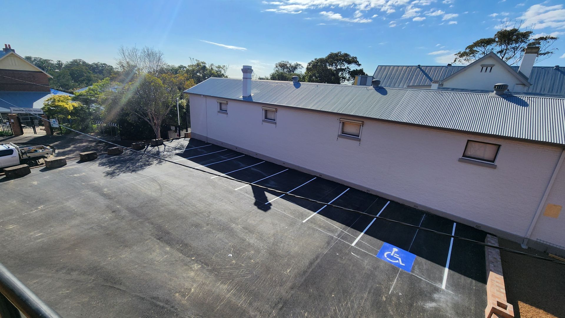 Parking Lot With Handicap Space In Front Of A White Building — TAC Asphalt Services in Warners Bay, NSW