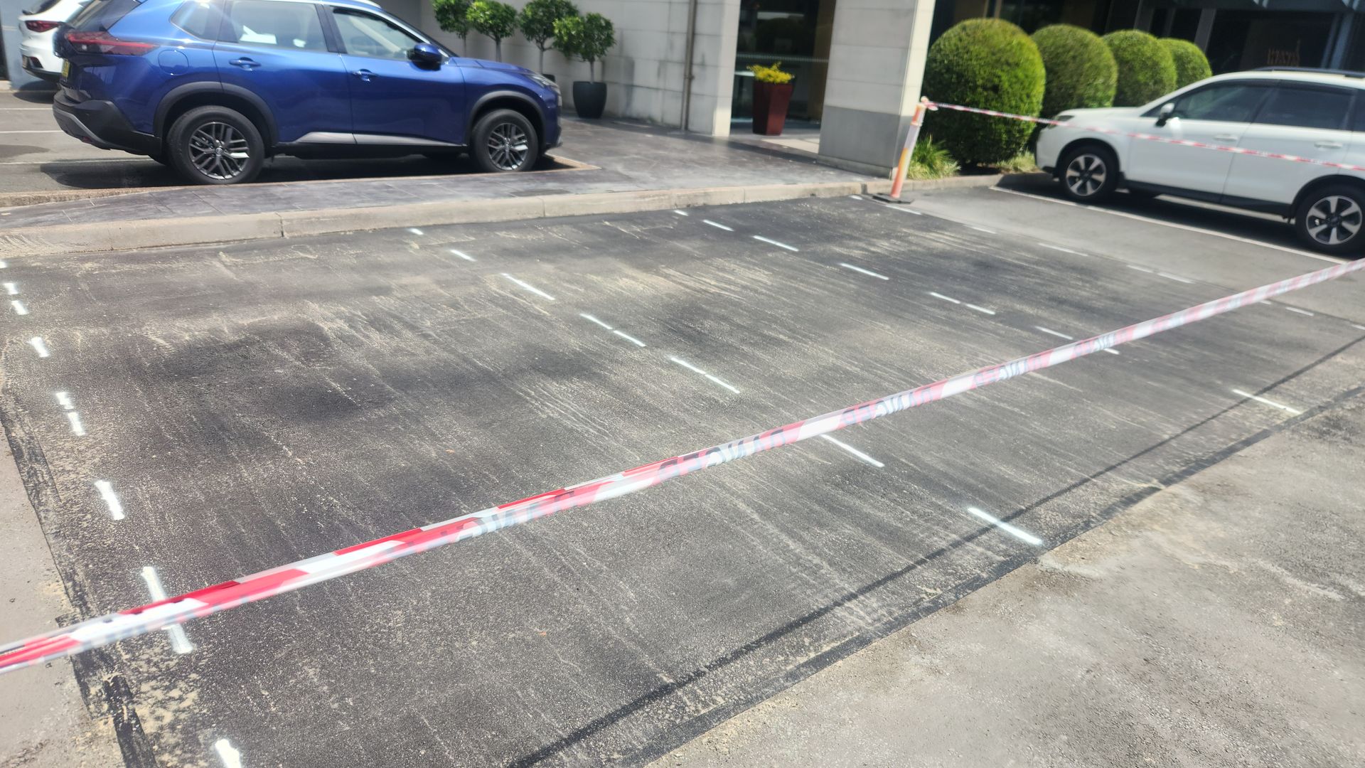 Parking Lot Repair With Red And White Tape — TAC Asphalt Services in Warners Bay, NSW