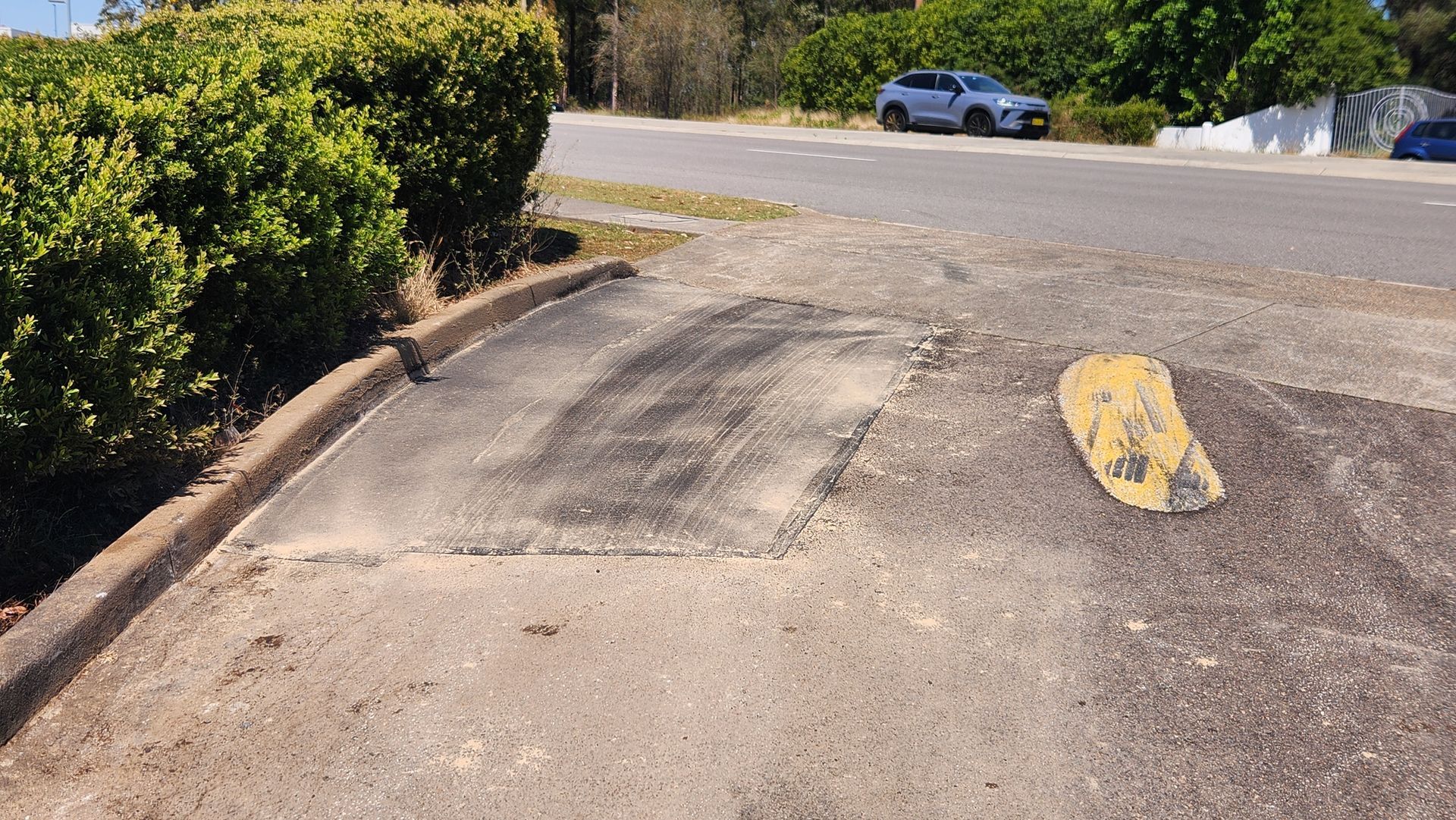Damaged Concrete Curb Cut Leading To A Residential Street — TAC Asphalt Services in Warners Bay, NSW