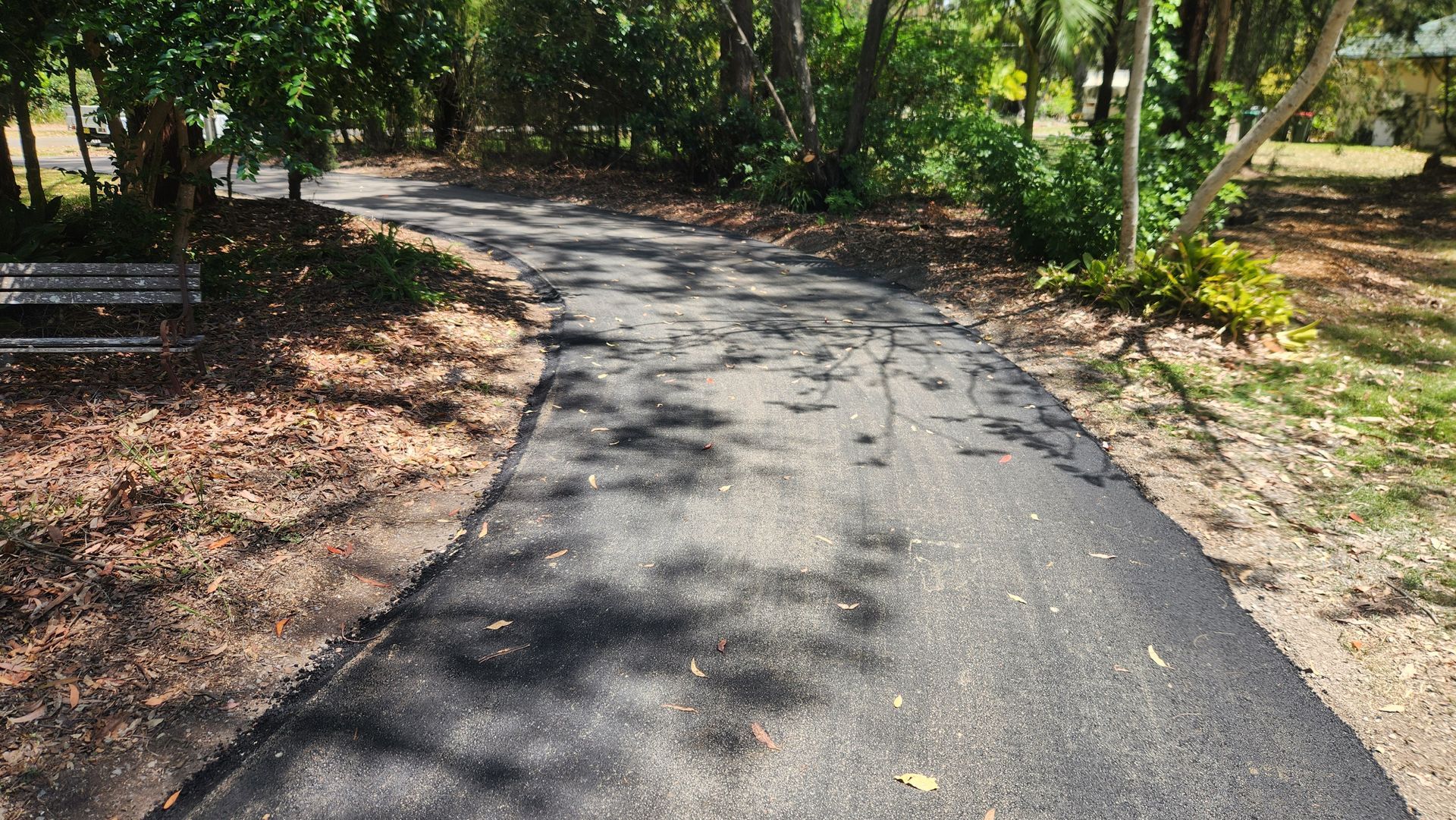 Asphalt Path Through Park, Surrounded by Trees, With a Bench on the Left — TAC Asphalt Services in Central Coast, NSW