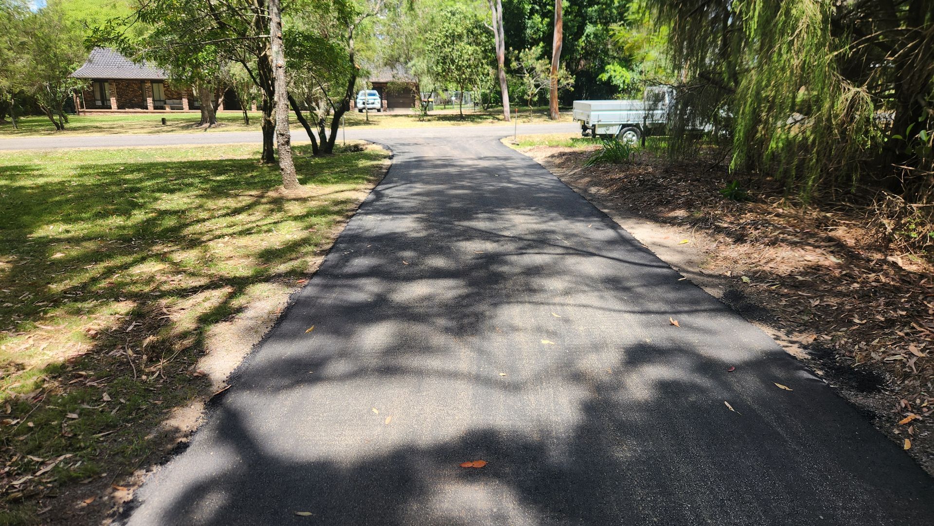 Asphalt Path Through a Park, With Trees on Either Side and Buildings — TAC Asphalt Services in Warners Bay, NSW
