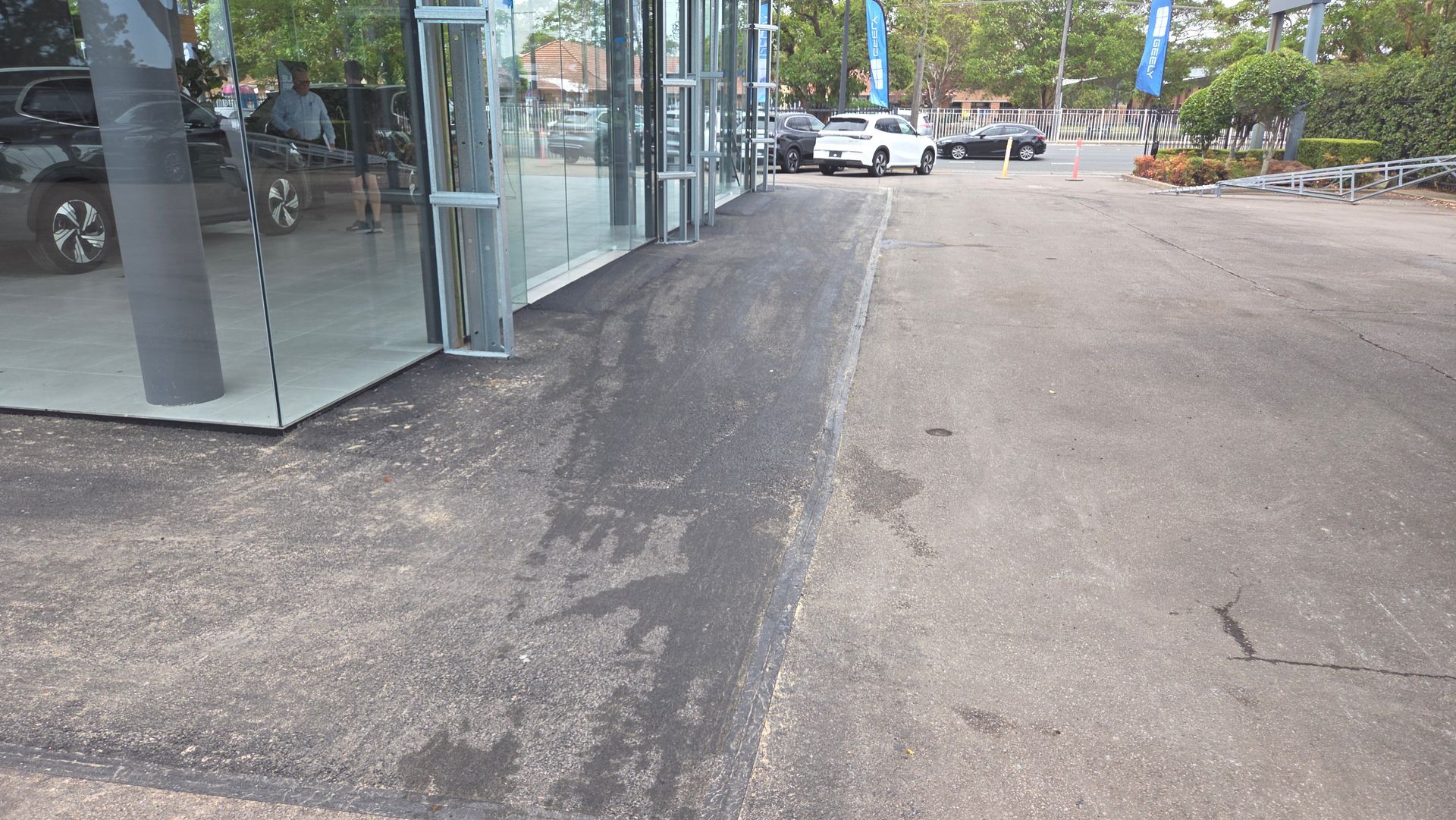 Asphalt Driveway Next To A Glass-walled Building — TAC Asphalt Services in Warners Bay, NSW