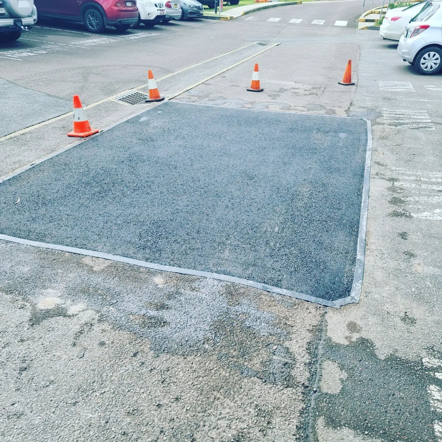 Newly Paved Asphalt Patch in a Parking Lot, Surrounded by Concrete — TAC Asphalt Services in Warners Bay, NSW