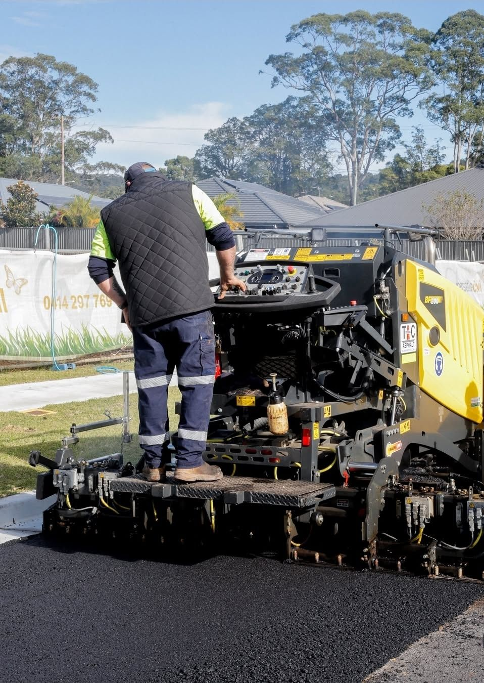 Construction Worker Operating Paving Machine, Laying Asphalt on a Road — TAC Asphalt Services in Warners Bay, NSW
