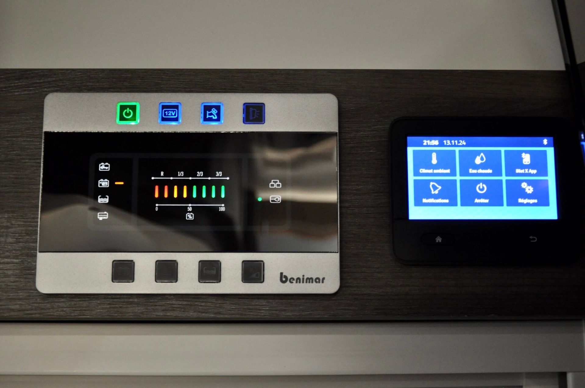 Bedieningspaneel met knoppen en display in een recreatievoertuig.