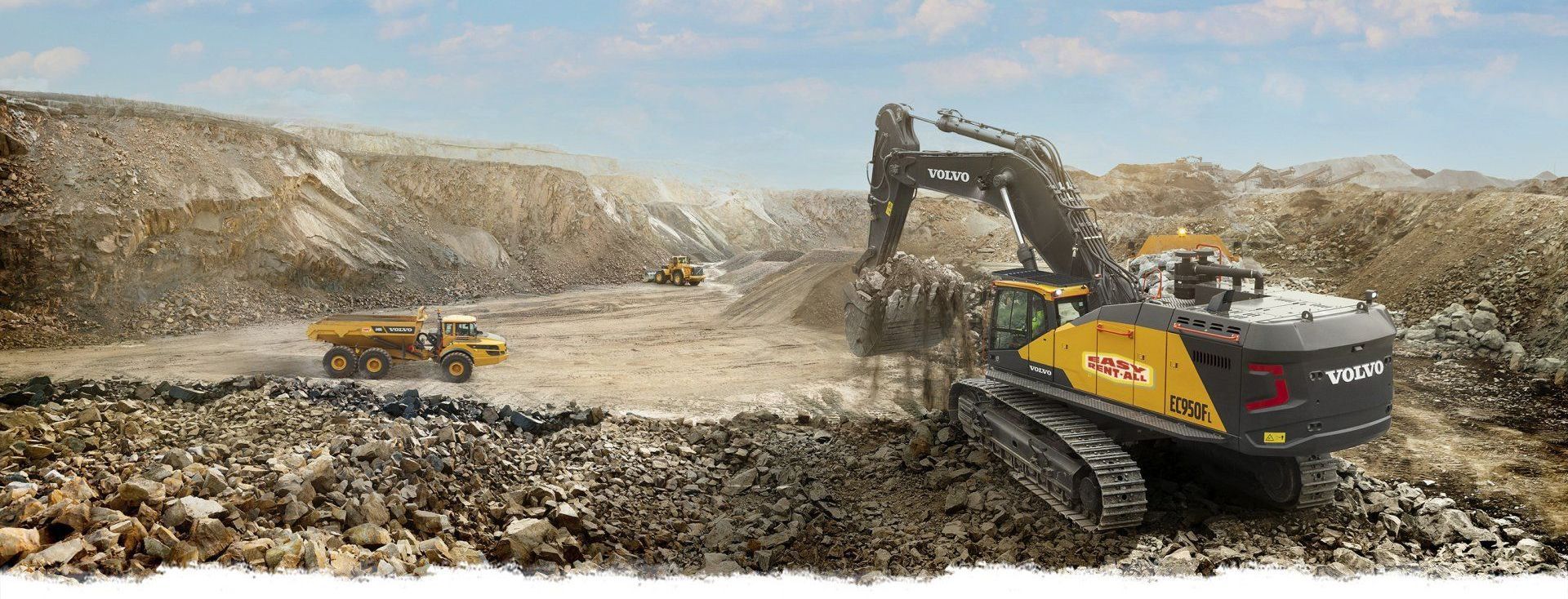 a bulldozer is driving through a dirt field next to a dump truck .