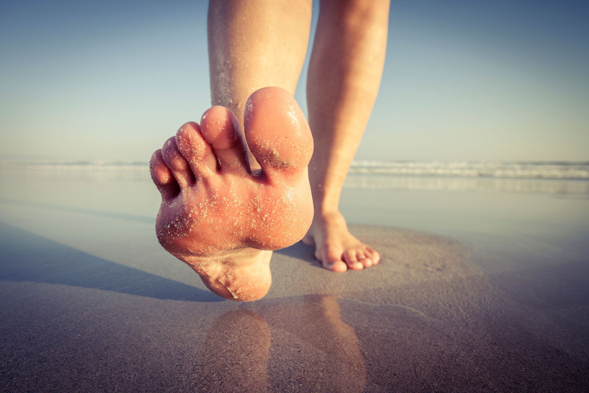 Bare feet walking on a beach