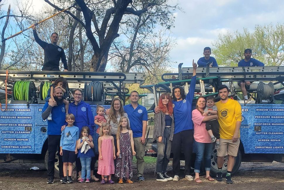 A large group of people are posing for a picture in front of a truck.