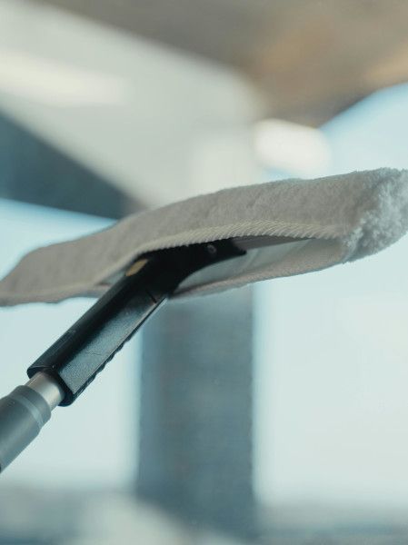 A person is cleaning a window with a scrubber