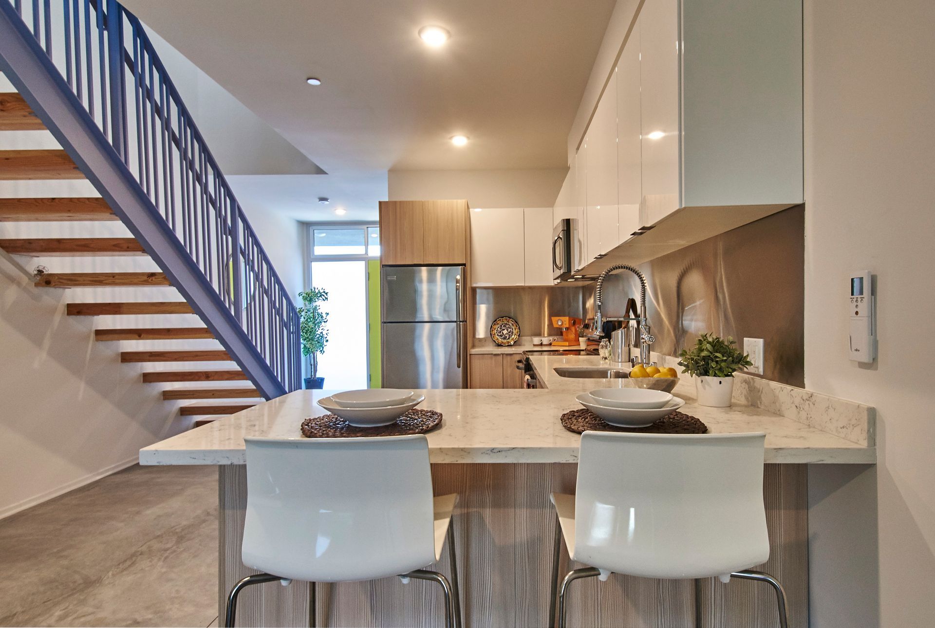 A kitchen with a staircase leading up to the second floor.