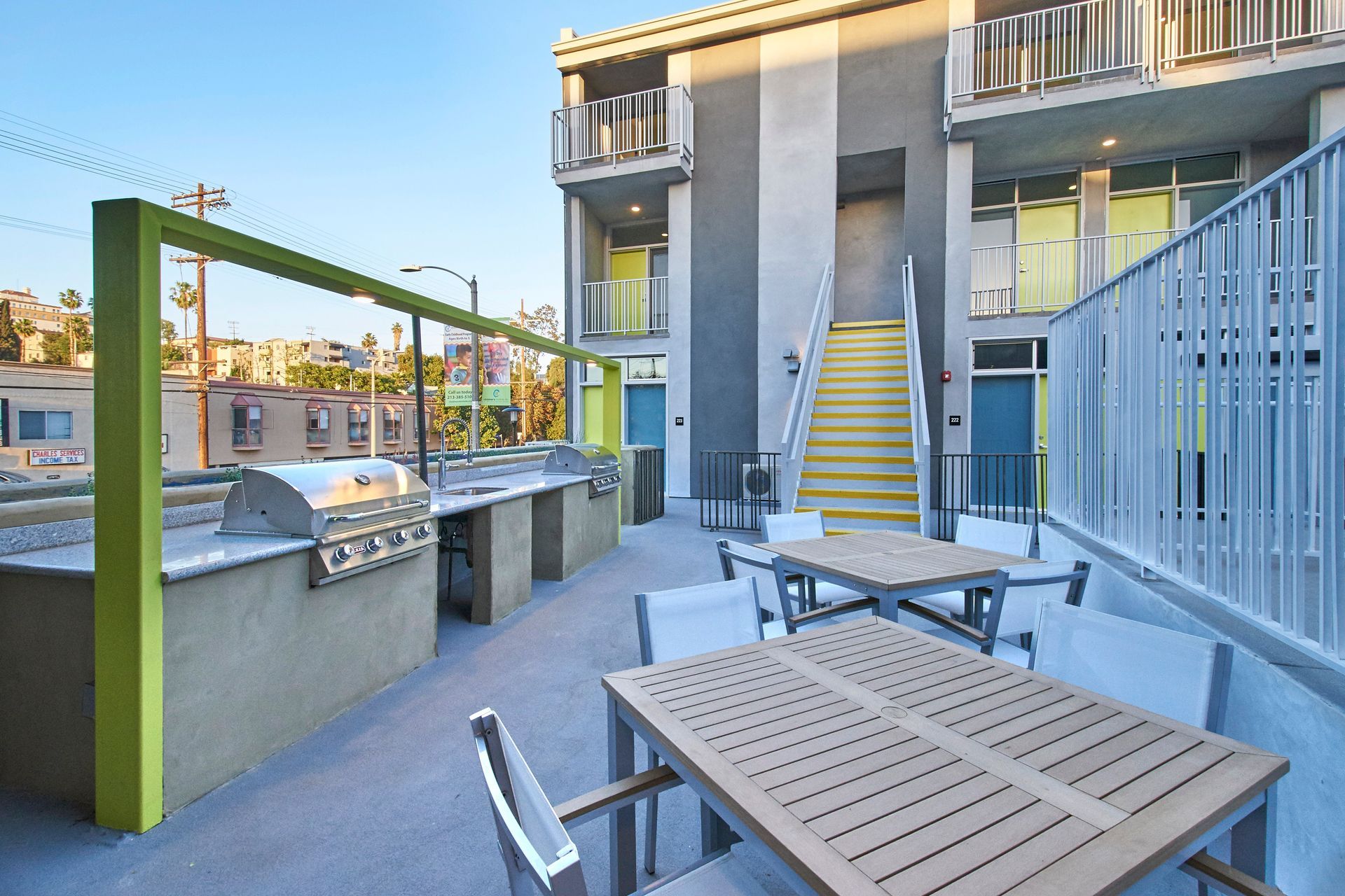 A patio area with a table and chairs and a grill.