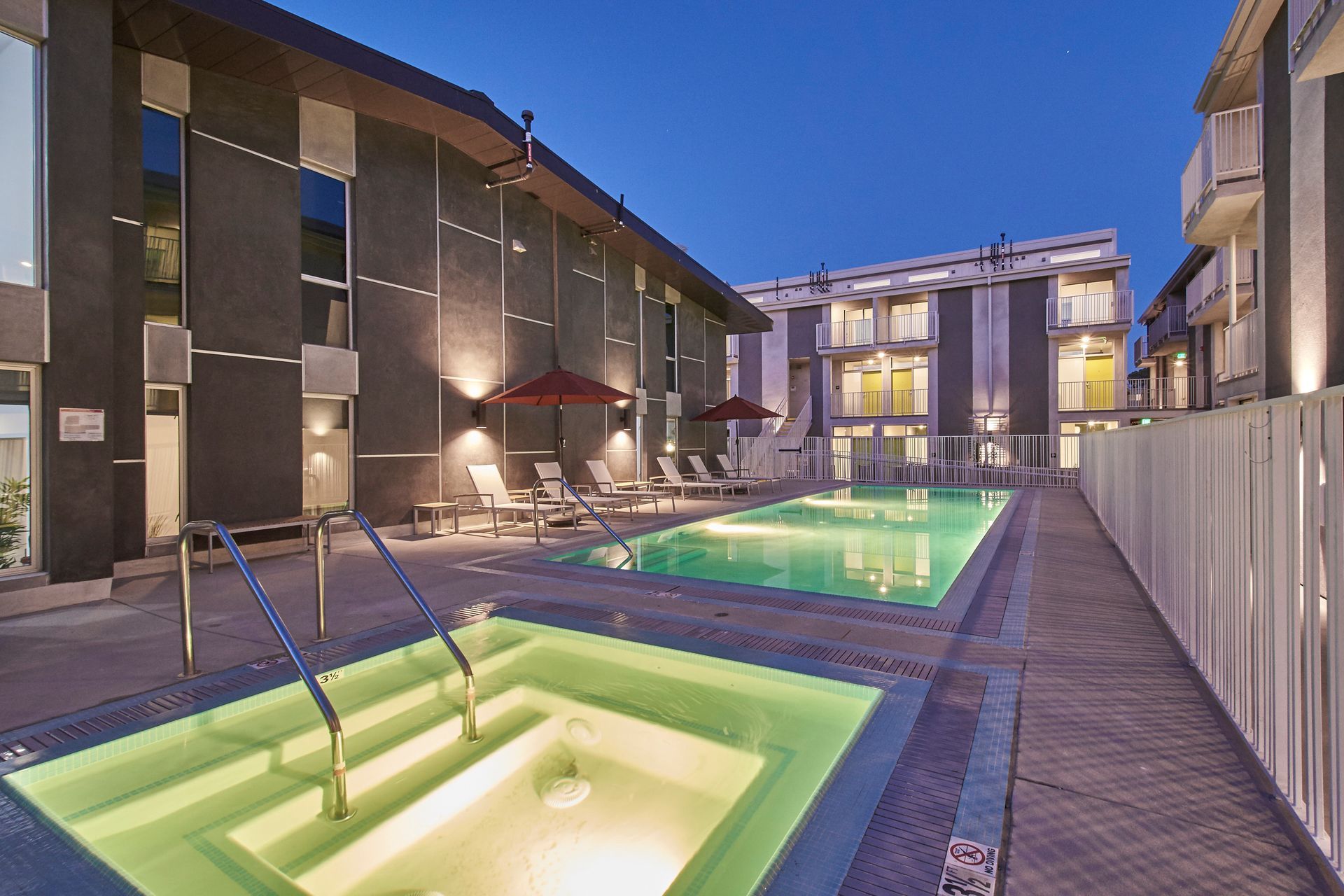 A large swimming pool in front of a building at night