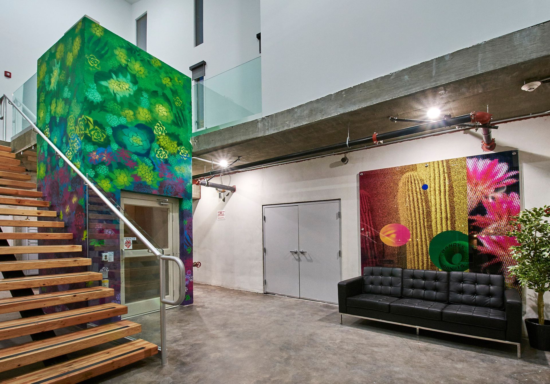 A room with stairs and a couch and a painting on the wall