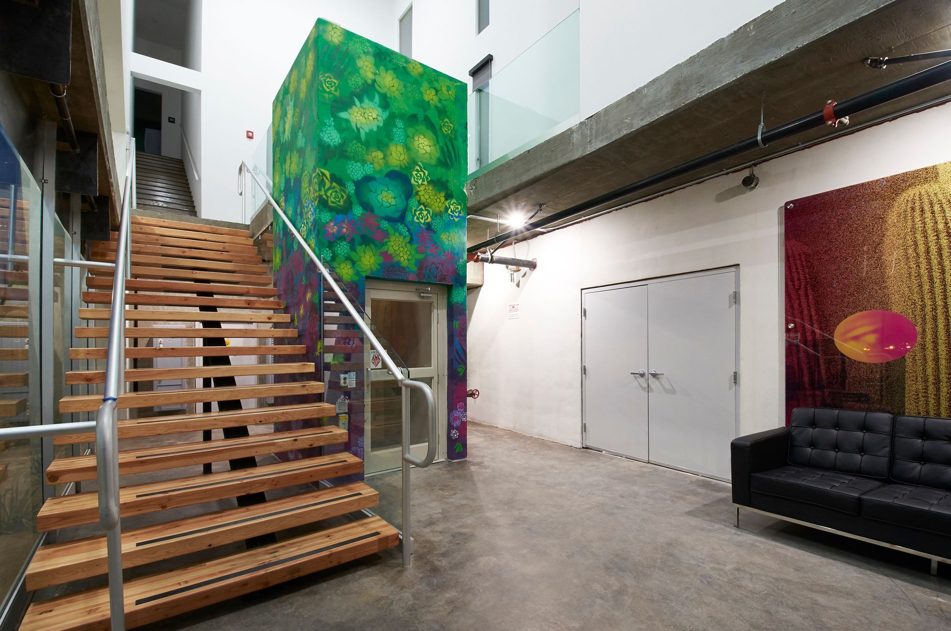 A staircase in a building with a painting on the wall