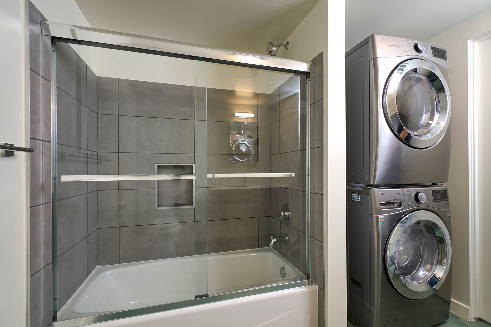A bathroom with a washer and dryer stacked on top of each other