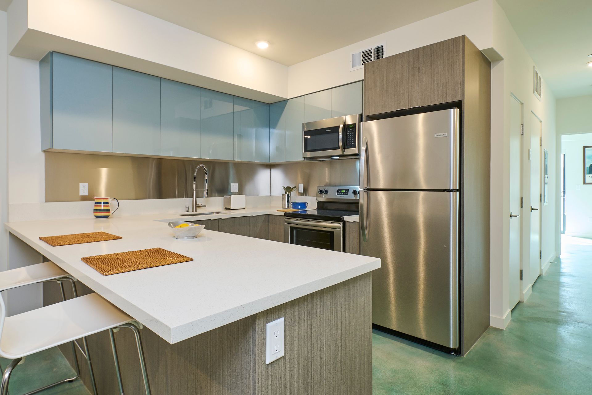 A kitchen with stainless steel appliances and a white counter top