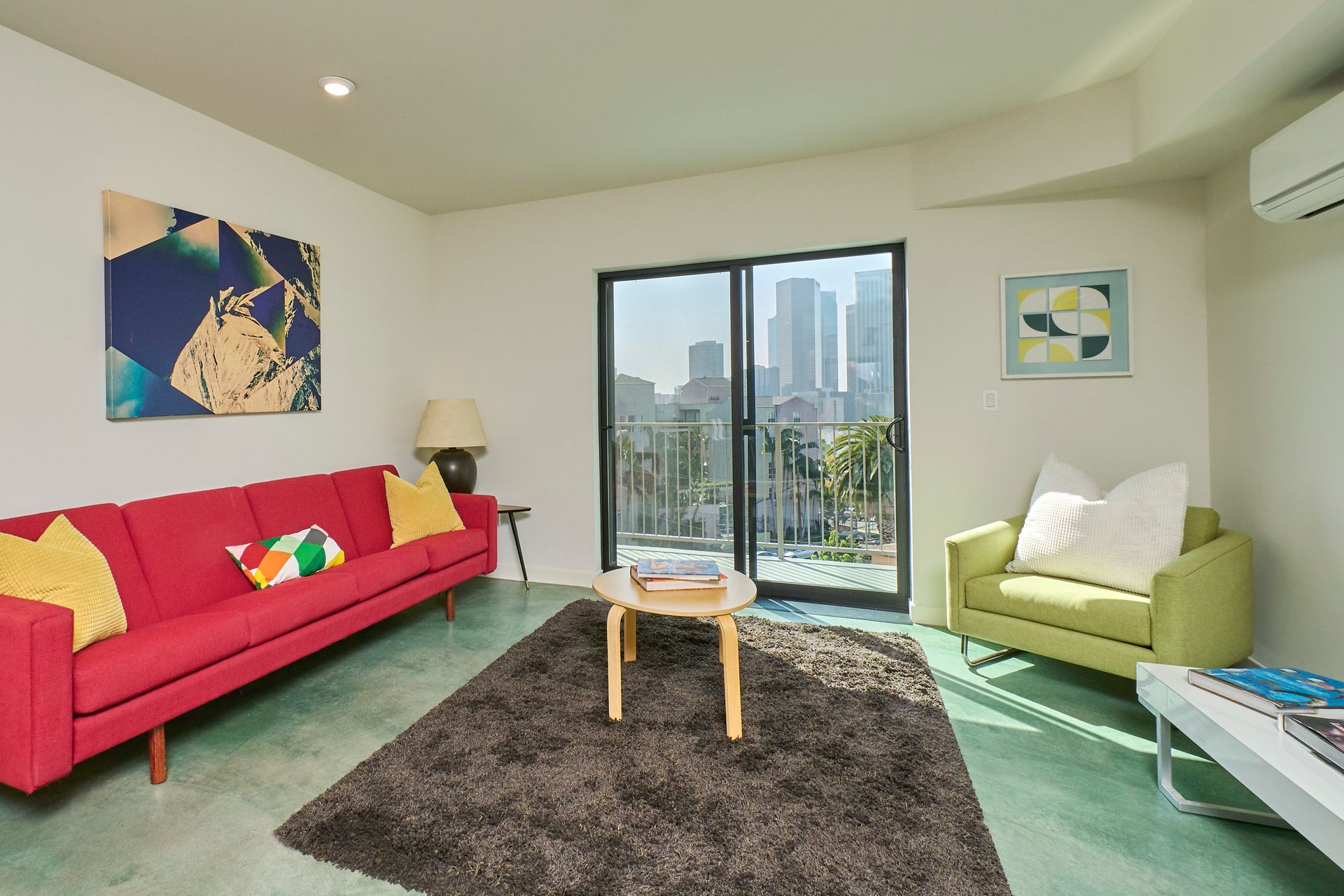 A living room with a red couch and green chairs