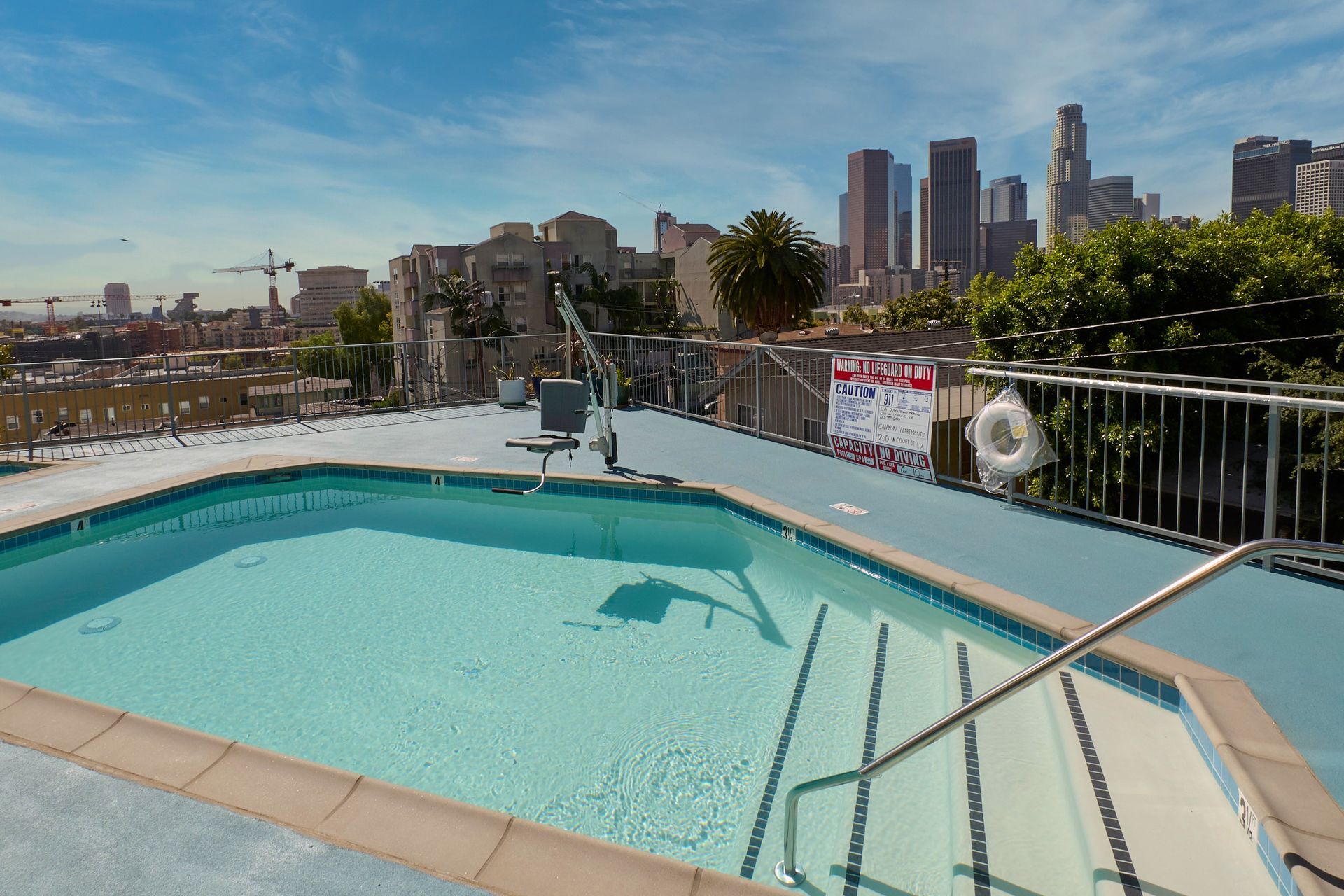 A large swimming pool with a city skyline in the background