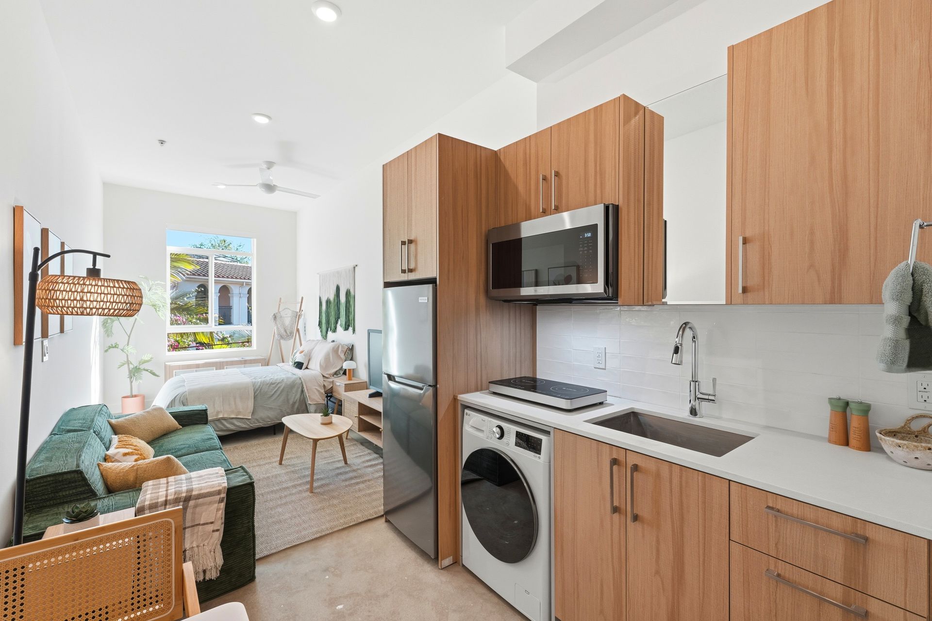 Small studio apartment with wooden cabinetry, kitchen, and living area.