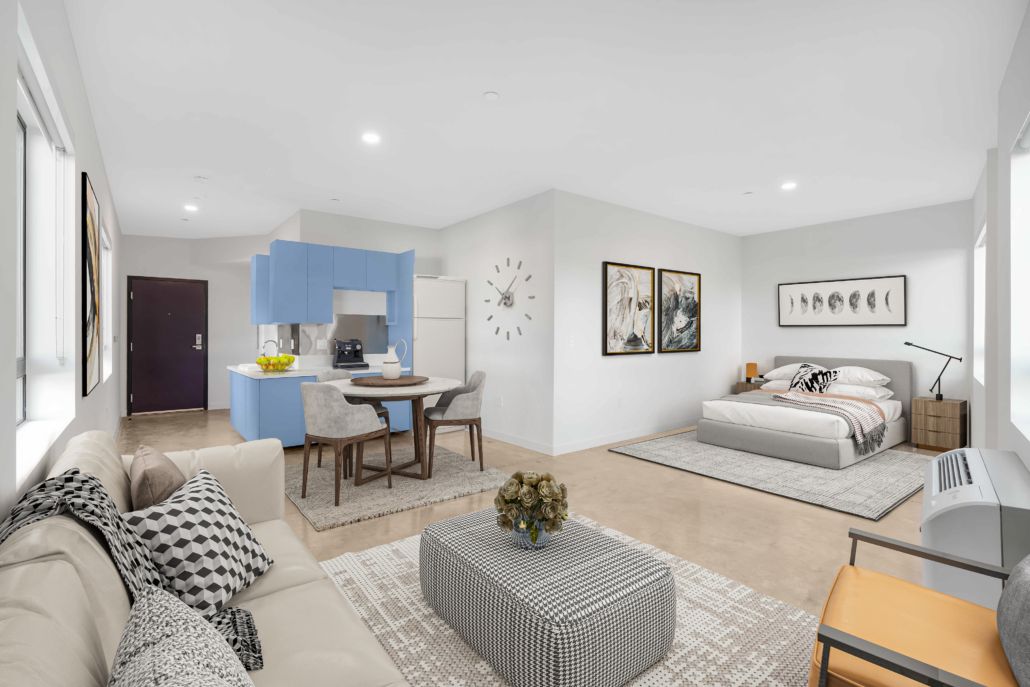 A living room with a couch , table , chairs and a bed.