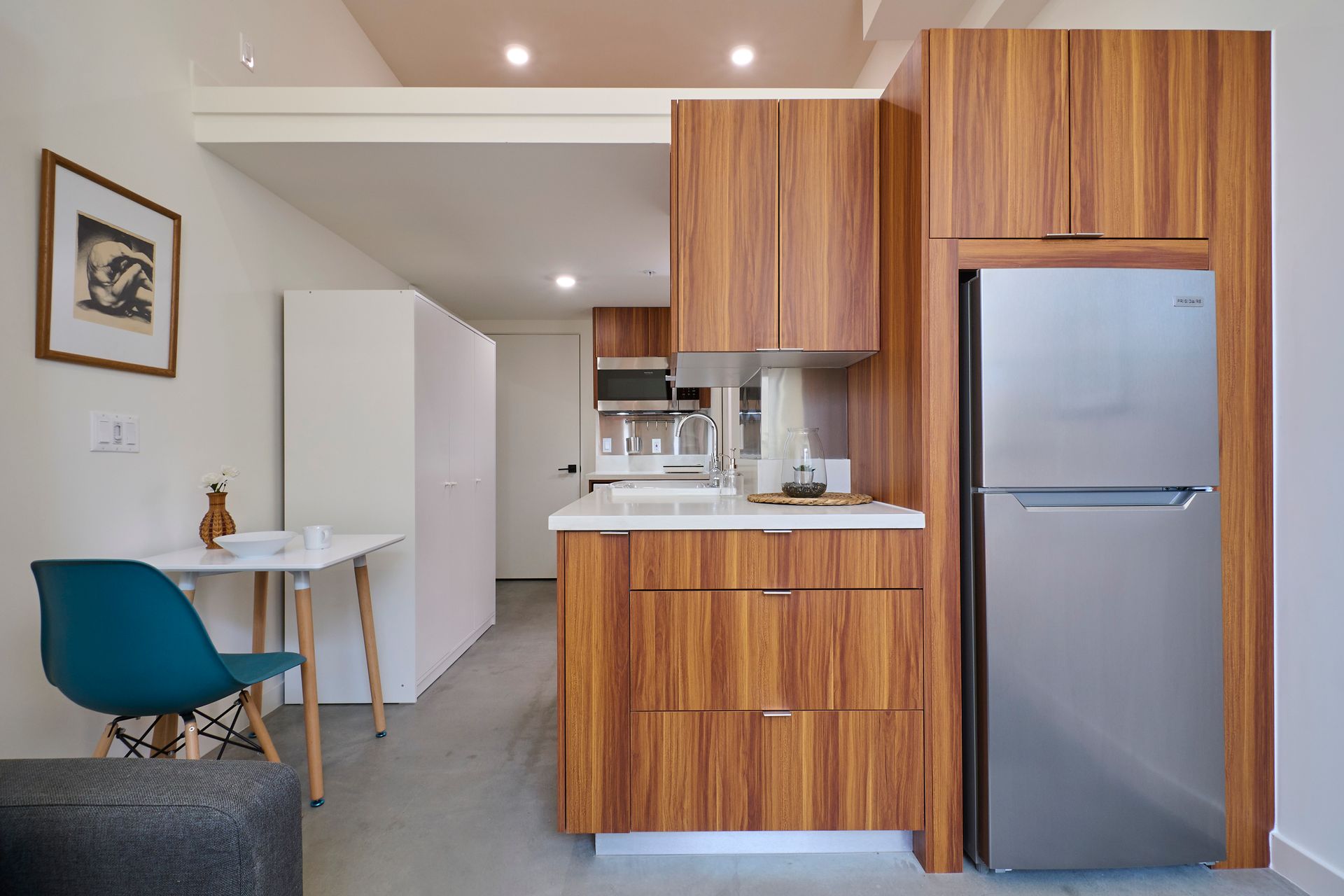 A kitchen with wooden cabinets and a stainless steel refrigerator