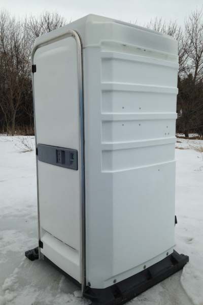 A white portable toilet is sitting in the snow