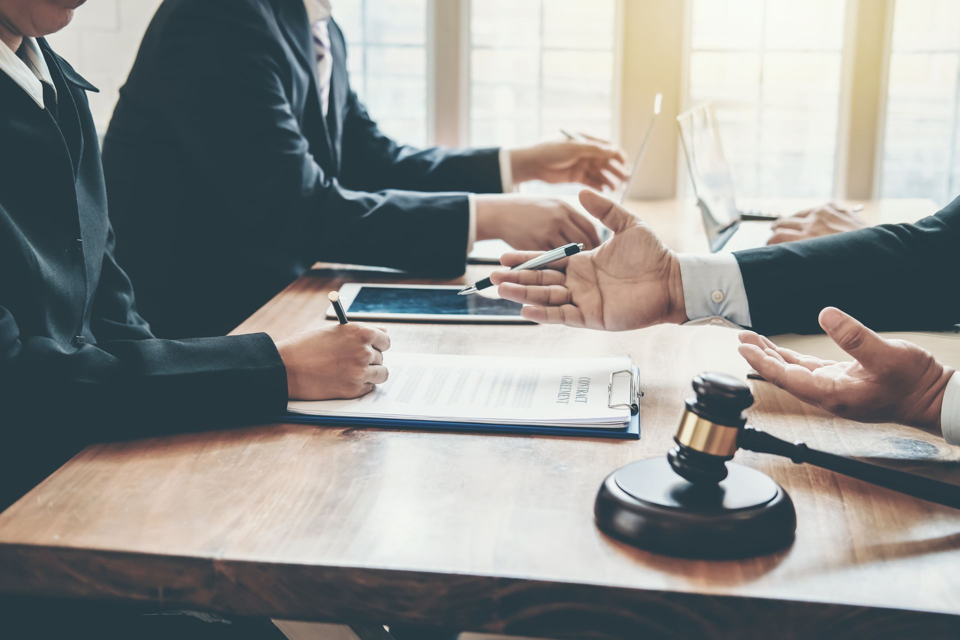 A group of people are sitting at a table with a judge 's gavel.